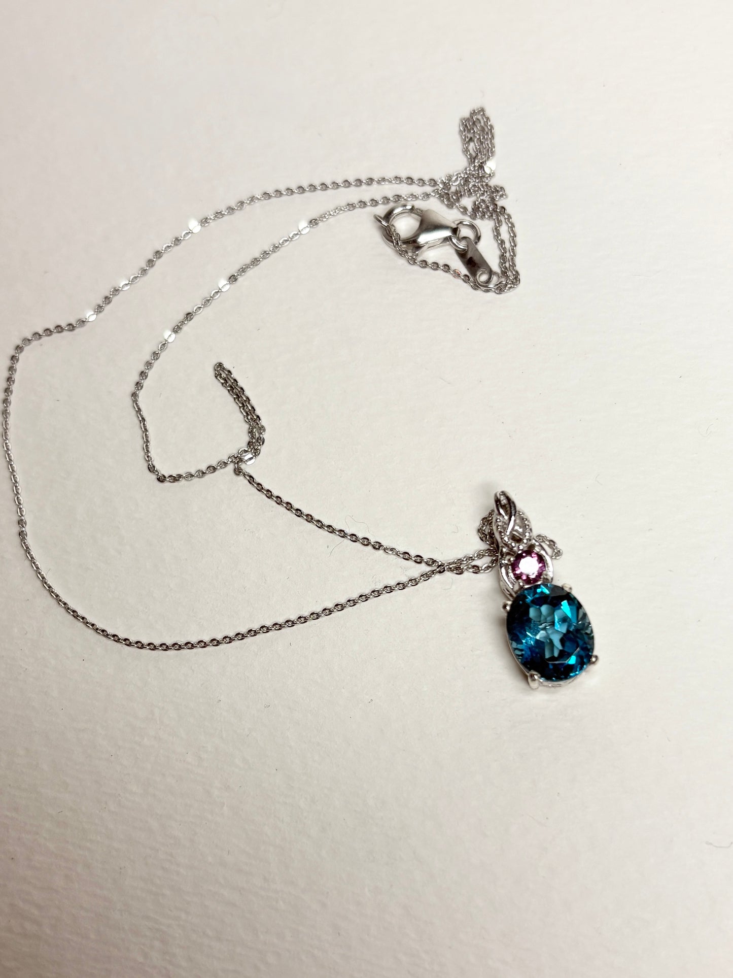 Sterling silver necklace with oval London blue topaz and round rhodolite garnet pendant.