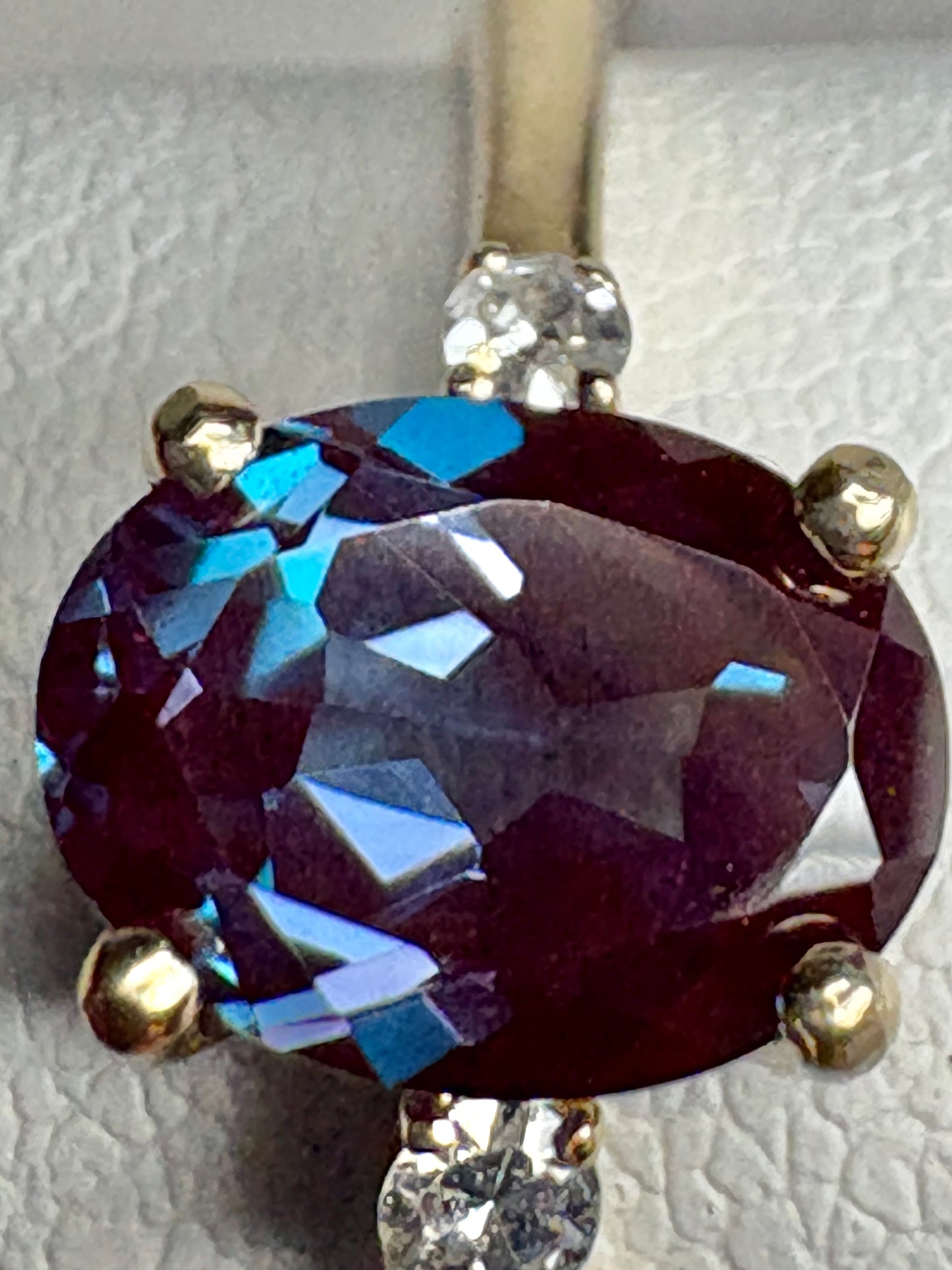 Oval lab-grown alexandrite and diamond ring in 10k gold.