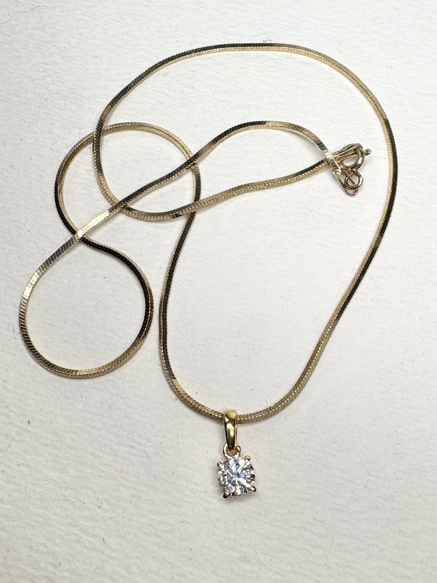 Gold over sterling silver snake chain necklace with a moissanite solitaire pendant.