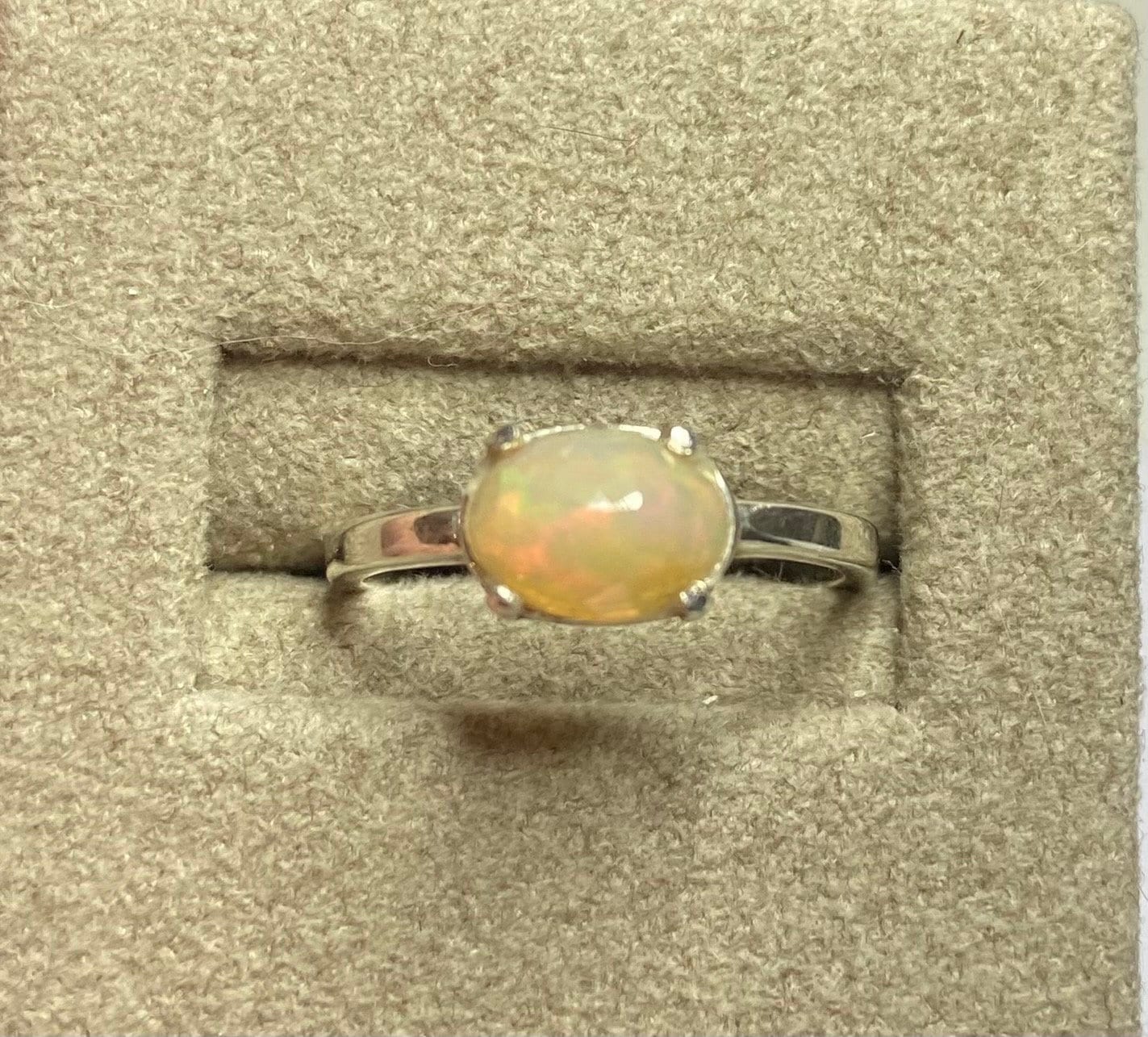 Oval faceted Ethiopian Wello opal band ring in sterling silver.