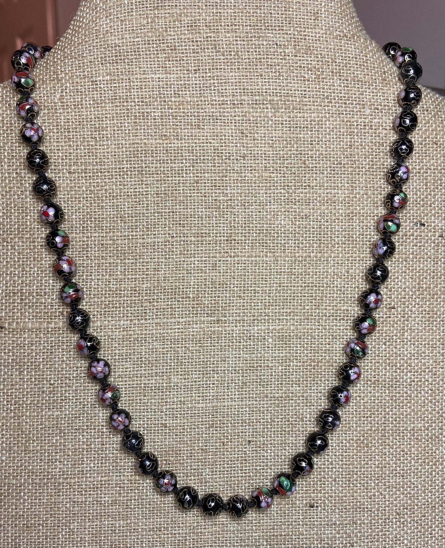 Cloisonné beaded necklace with black, pink, and gold floral designs.