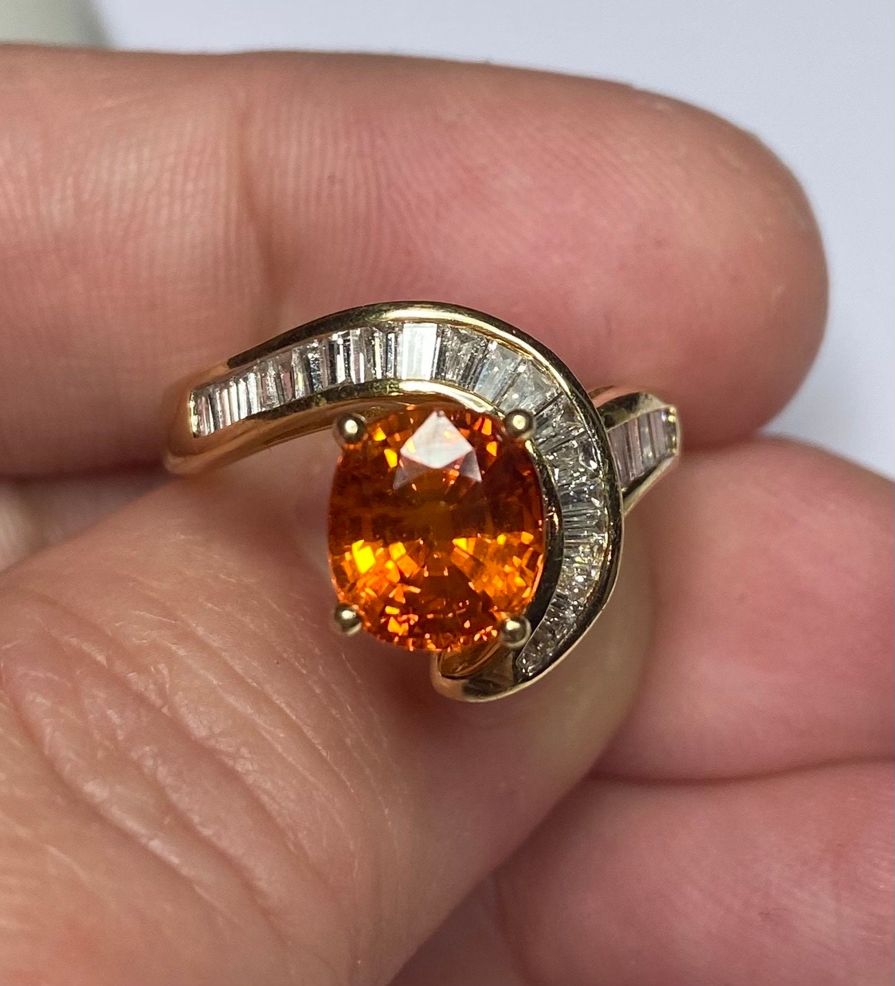 18k yellow gold ring with a spessartite garnet and baguette diamonds.