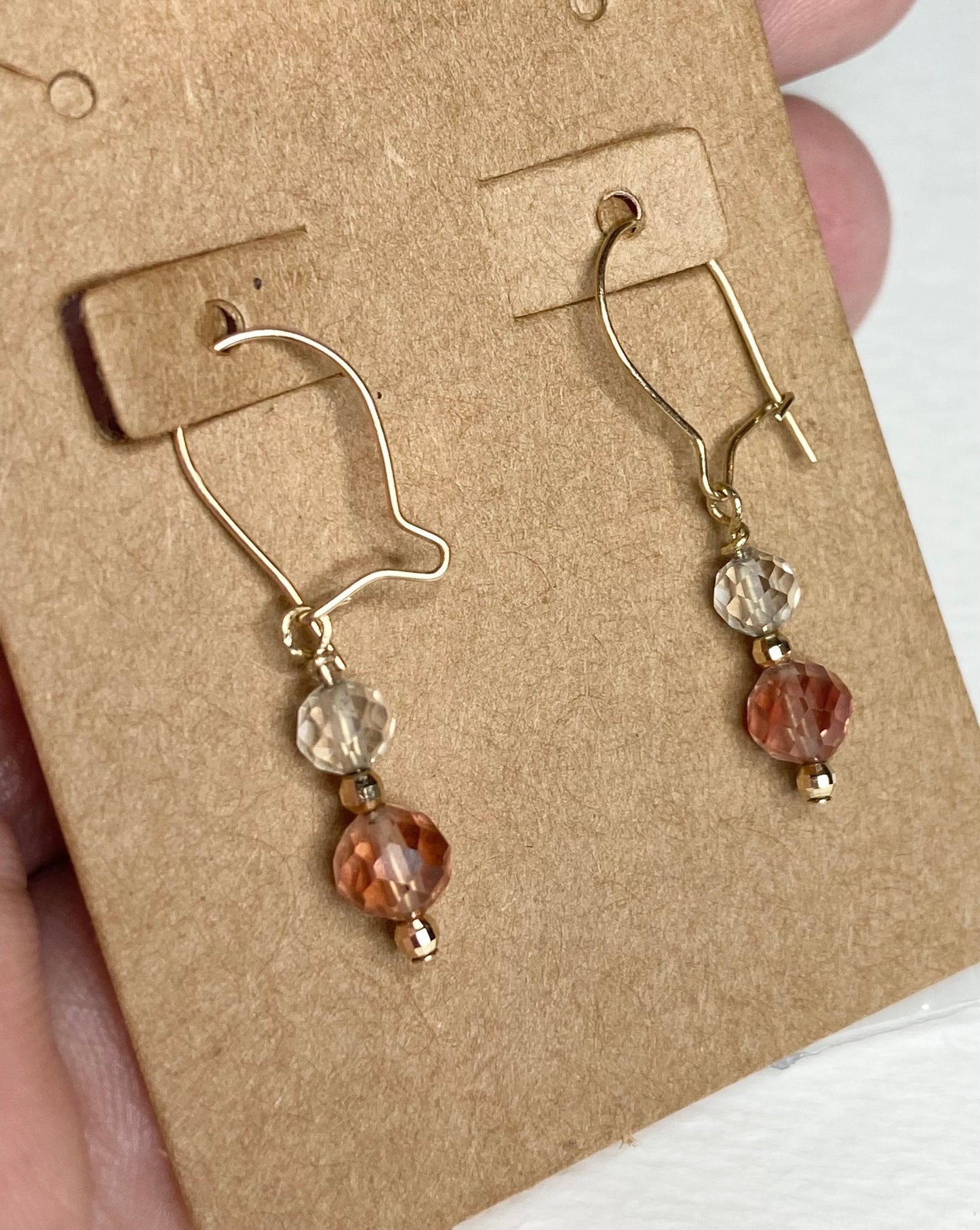 Solid 14k gold dangle earrings with faceted Oregon Sunstone beads in light yellow and red.