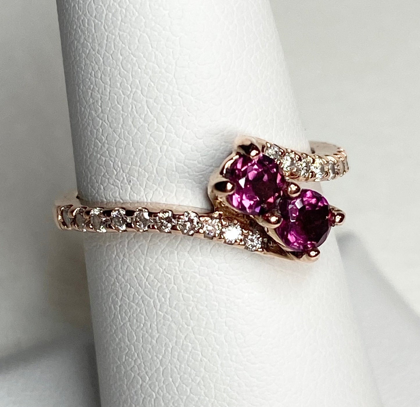 14k rose gold ring with two rhodolite garnets and diamonds.