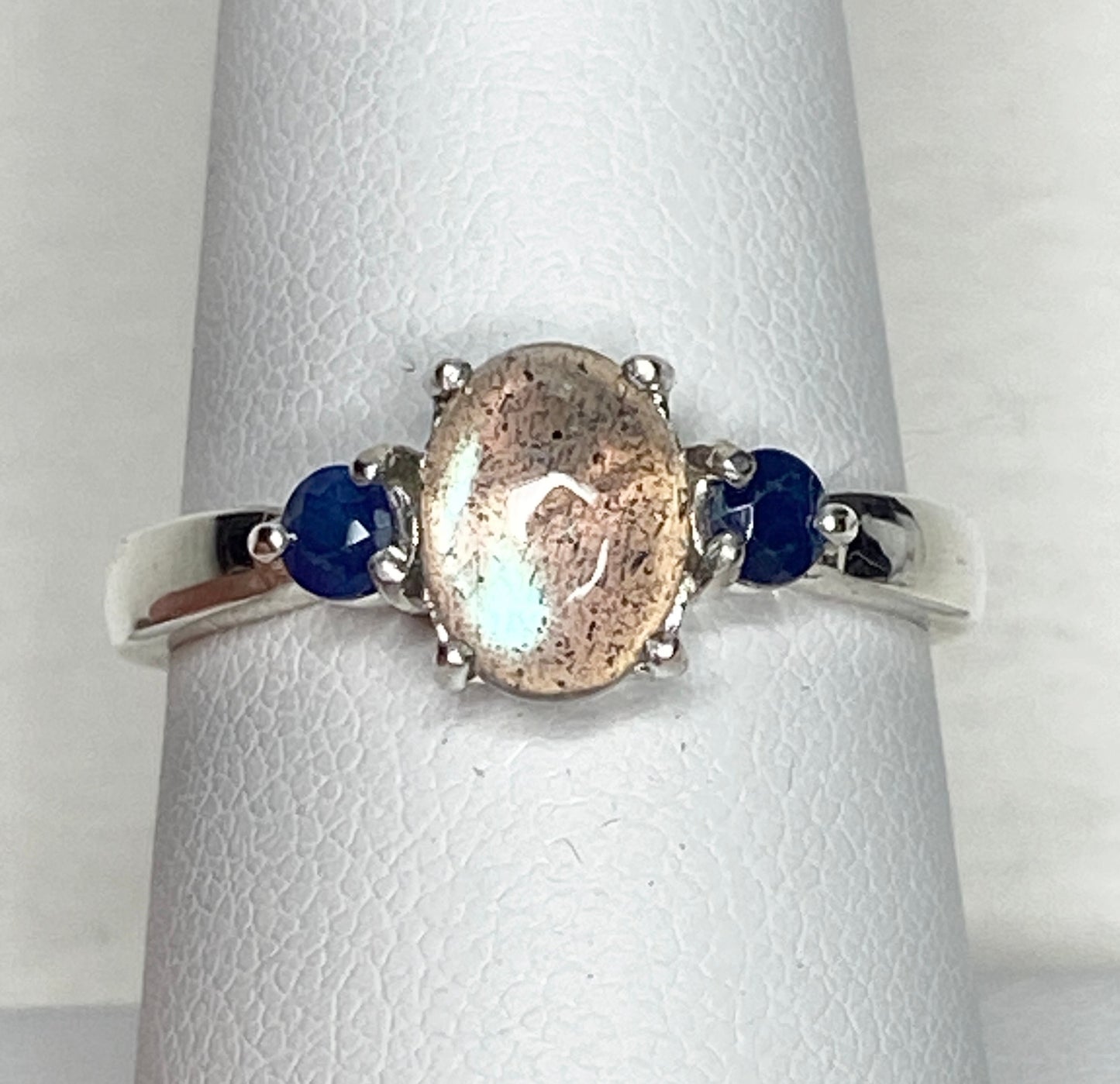 Sterling silver ring with oval labradorite and two round blue sapphires.
