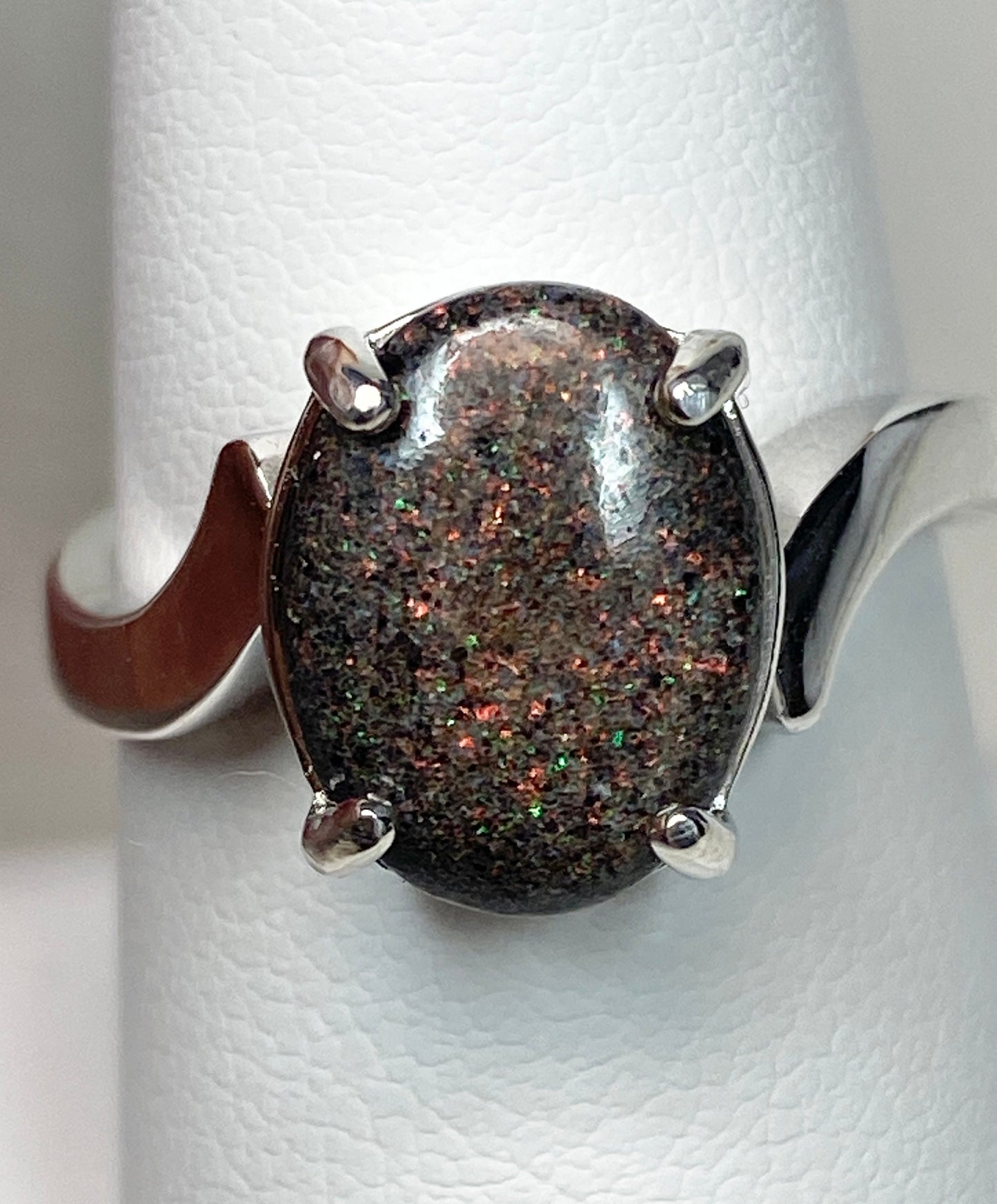 Sterling silver ring with an oval pinfire boulder opal cabochon.