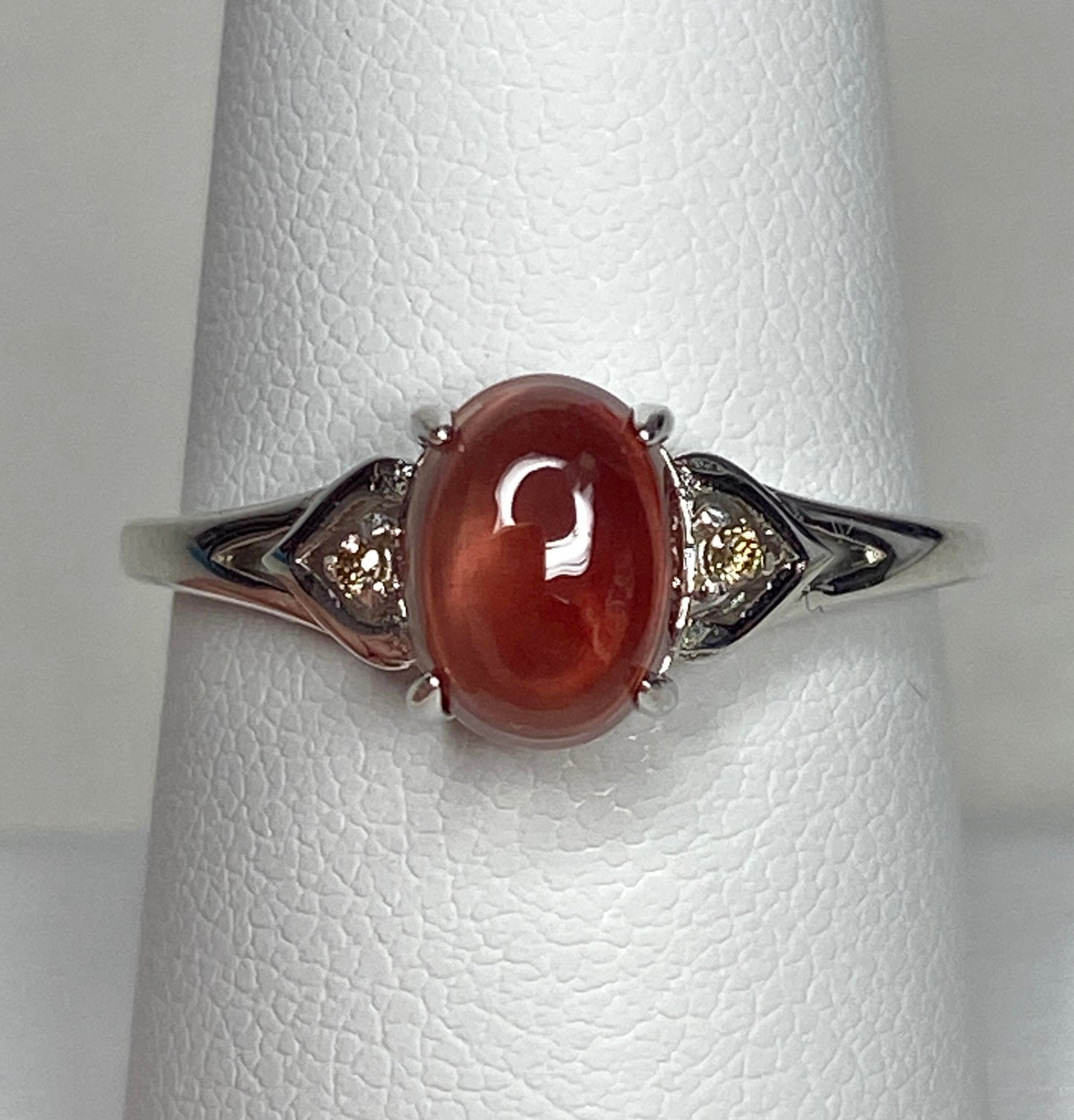 Sterling silver ring with oval red Oregon sunstone and brown diamonds.