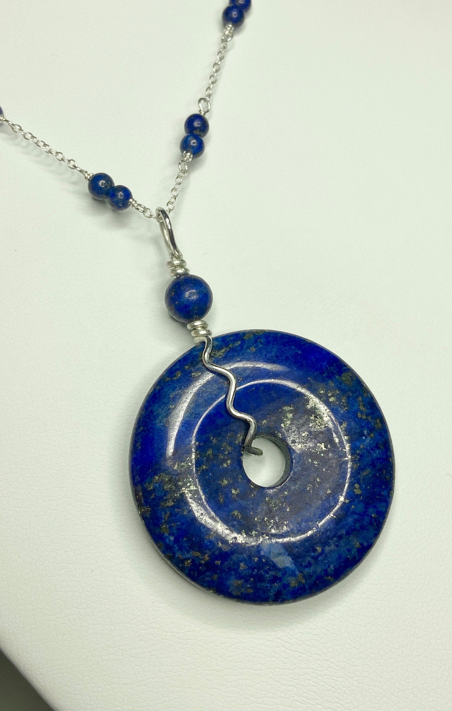 Lapis lazuli donut pendant necklace with sterling silver chain and beads.
