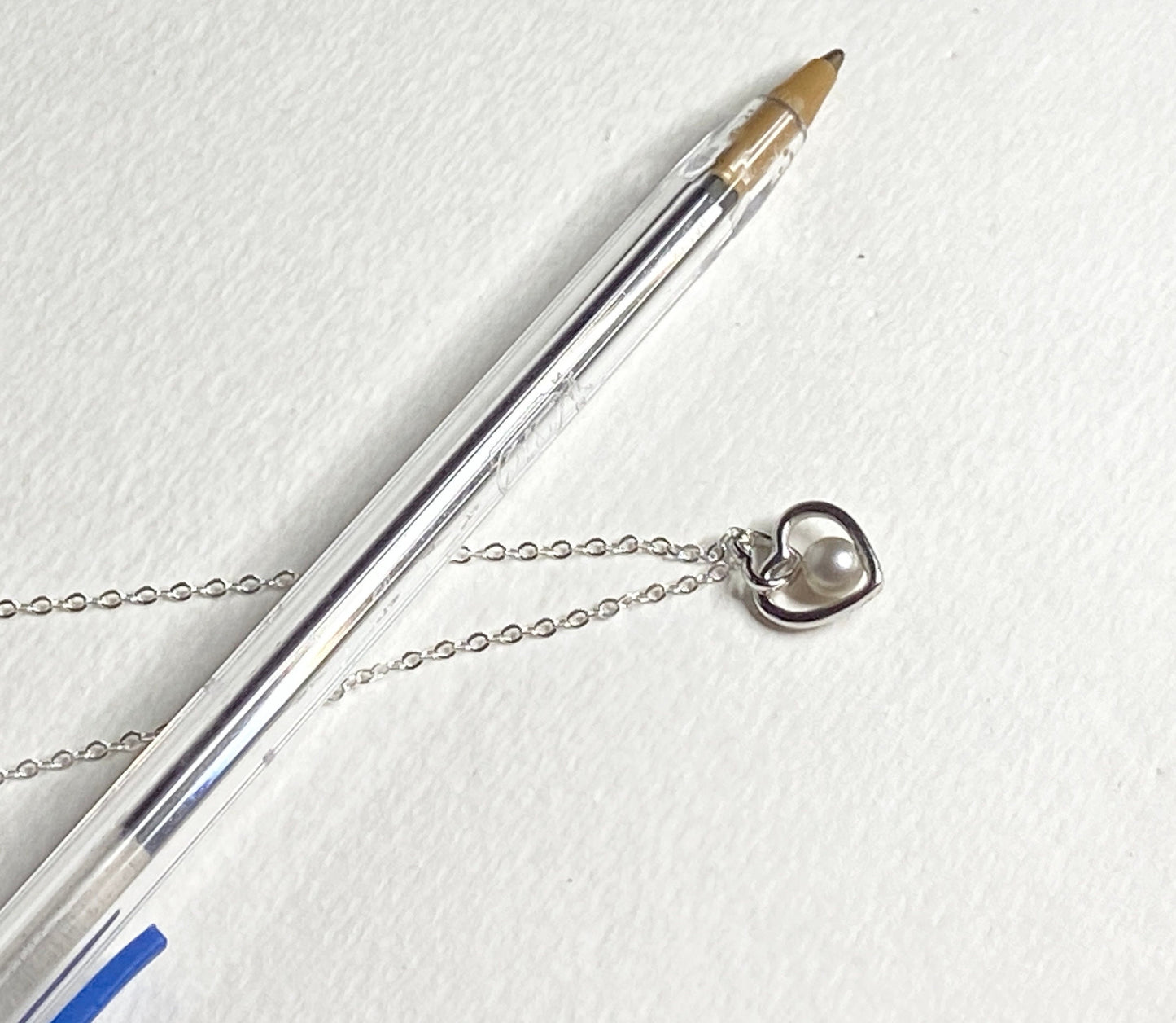 Sterling silver necklace with a double heart pendant and a 5mm cultured pearl.