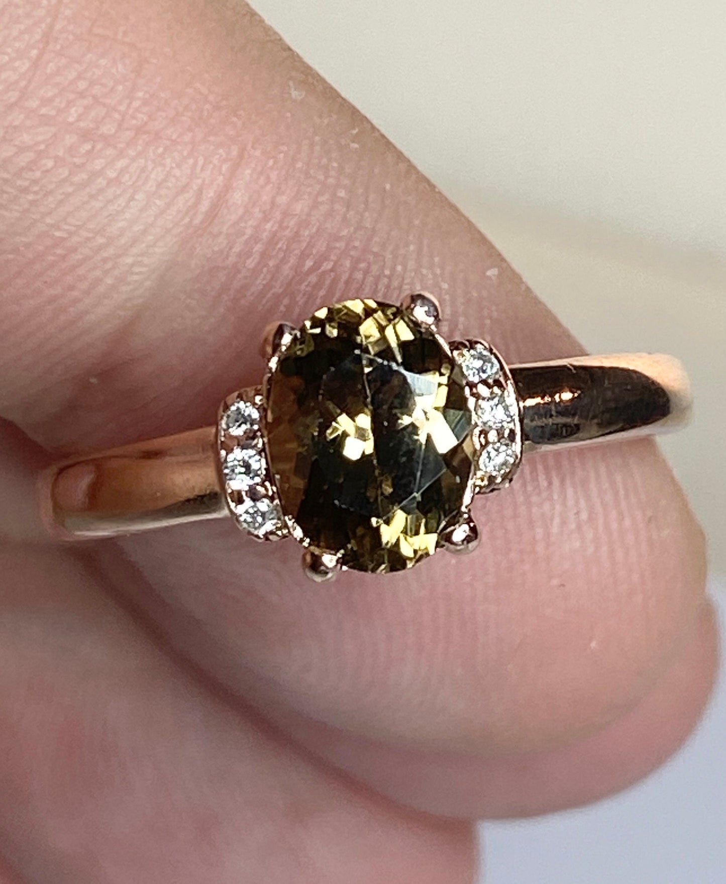 Oval greenish-gold zircon and diamond ring in 10k rose gold.