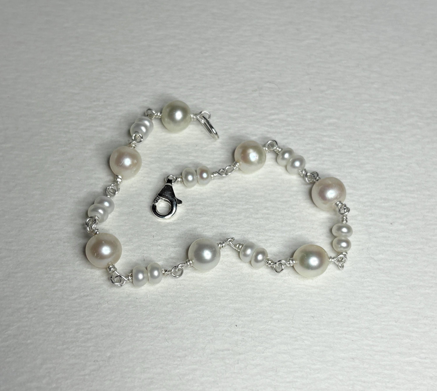 Sterling silver bracelet with cultured freshwater pearls.