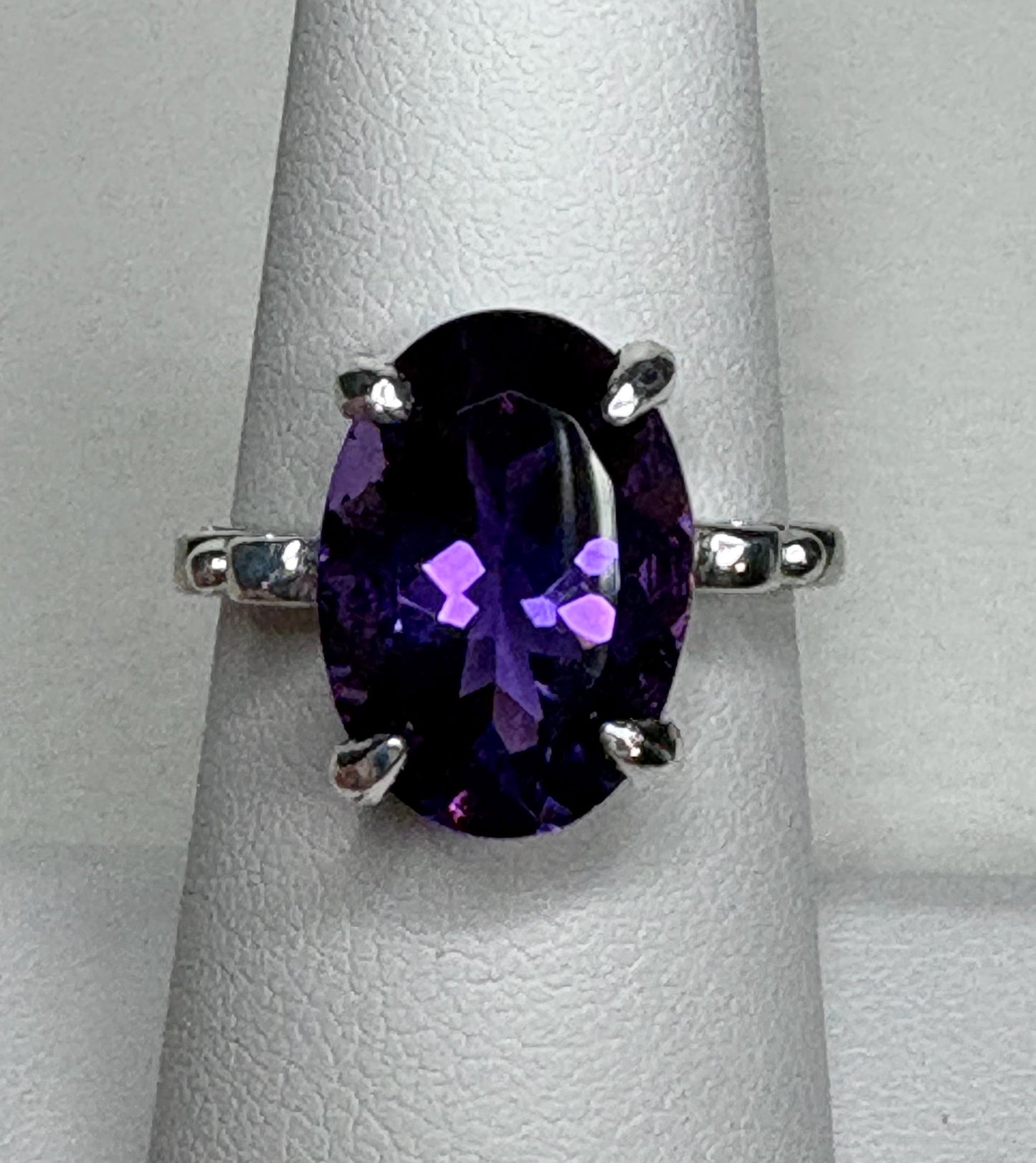 Sterling silver ring with a large oval amethyst gemstone.