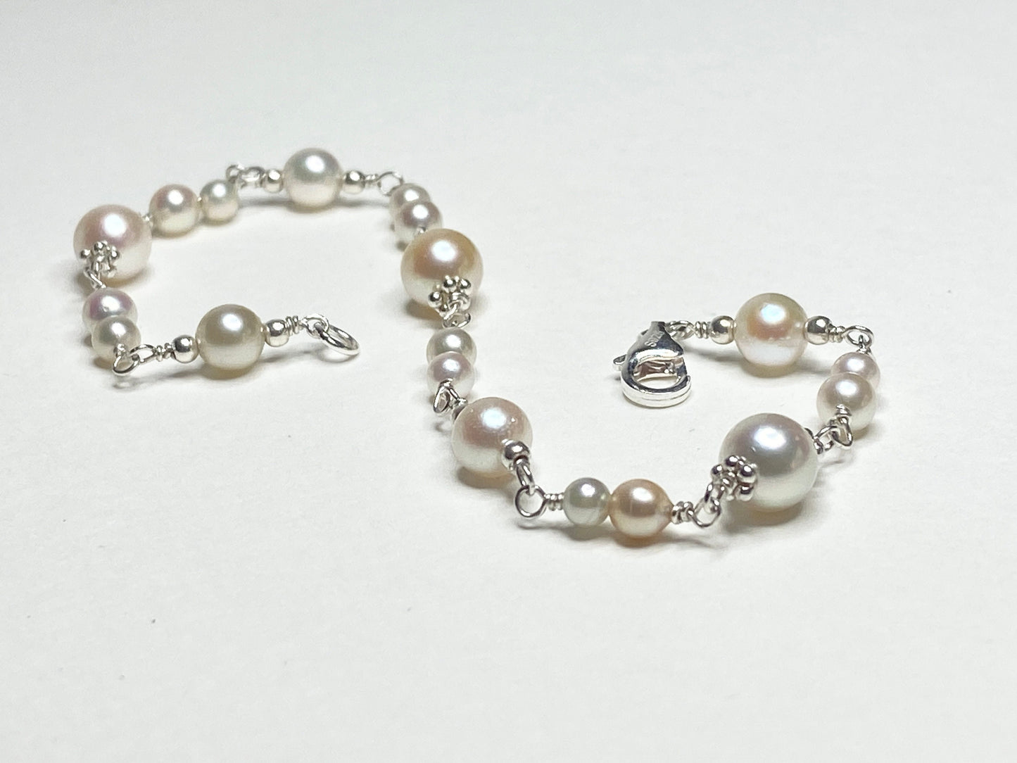 Sterling silver bracelet with multi-colored Akoya pearls of varying sizes.