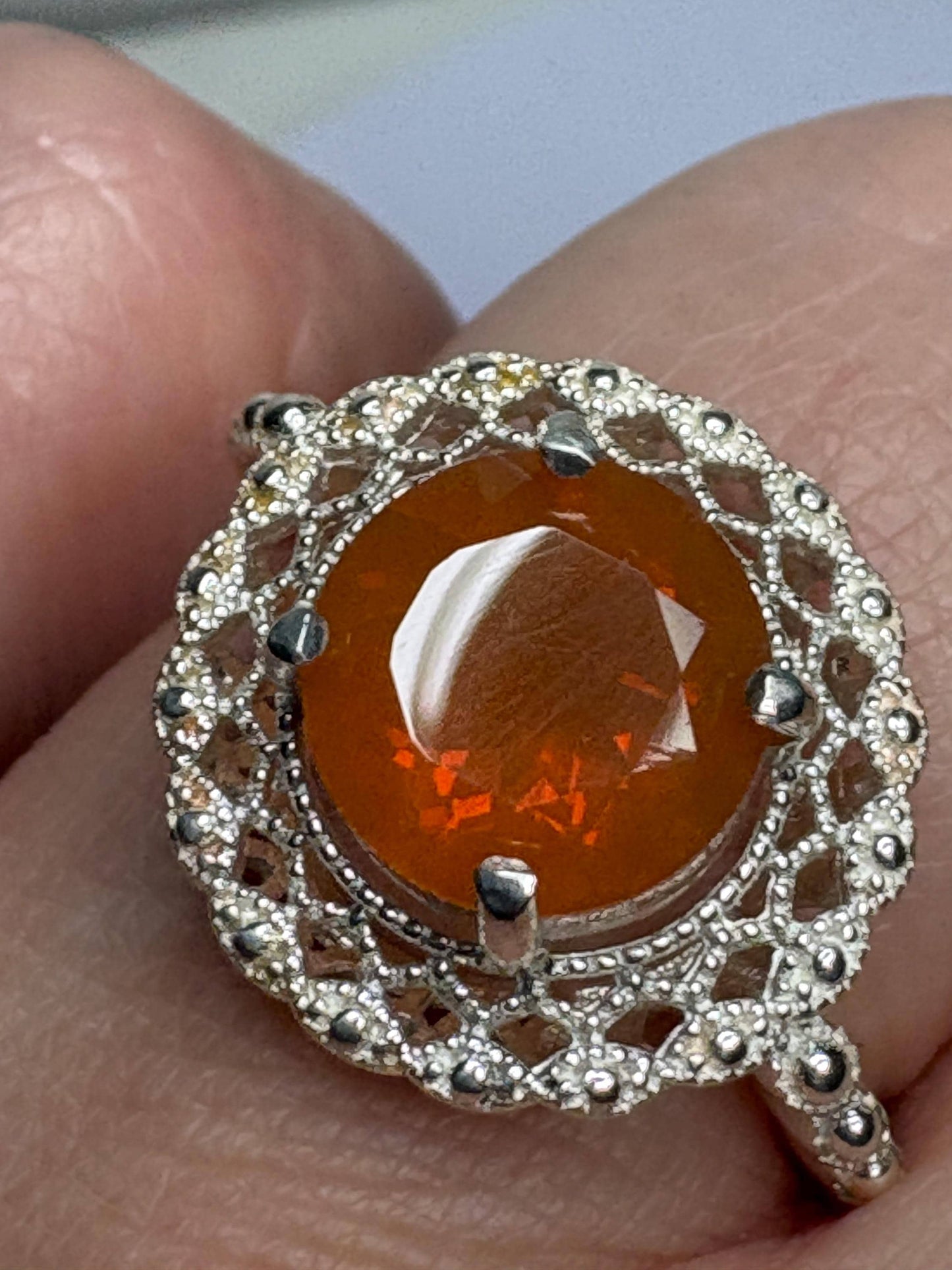 Sterling silver ring with a round Oregon fire opal and lacy filigree setting.