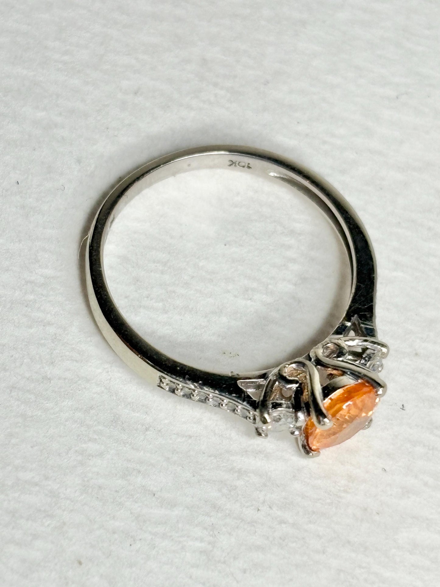 A 10k white gold ring with a Fanta orange spessartite garnet and diamonds.
