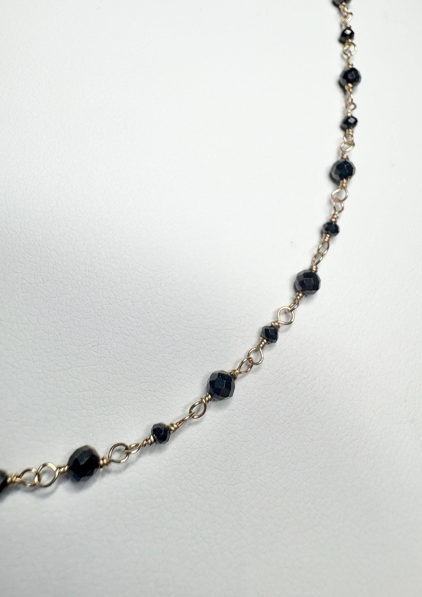 A delicate 14k gold bracelet with small faceted black diamond beads.