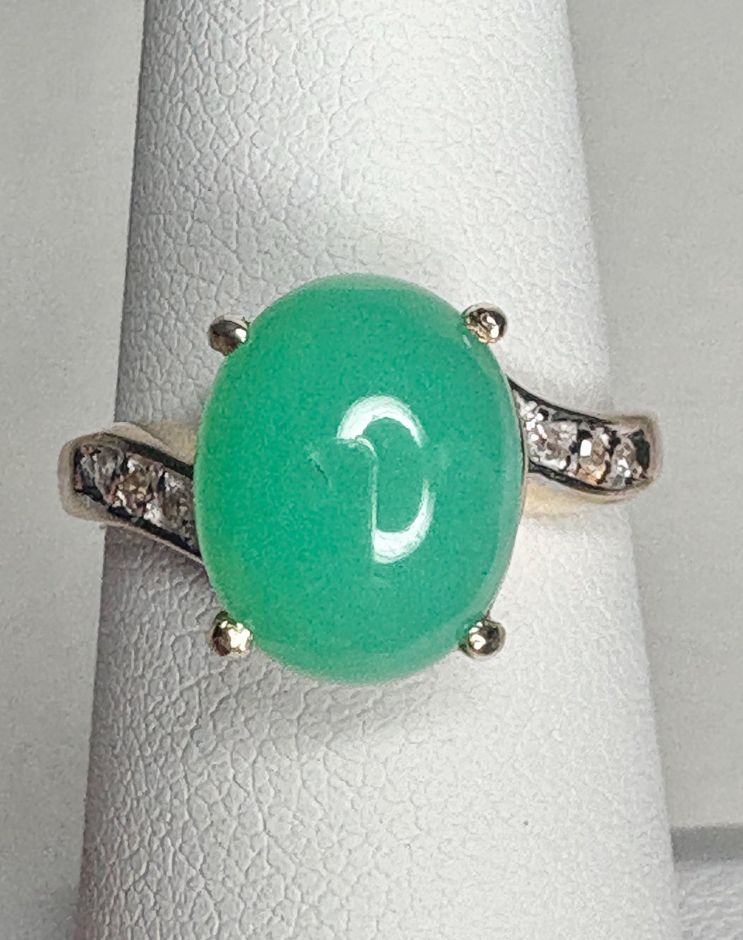 A 14k gold ring with a green chrysoprase stone and diamond accents.