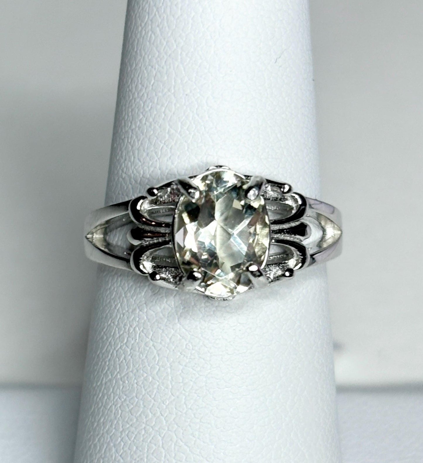 Sterling silver ring with an oval yellow sunstone and fleur de lis accents.