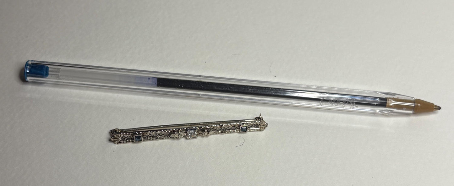 Antique 10k white gold bar brooch with an old mine cut diamond and simulated sapphires.