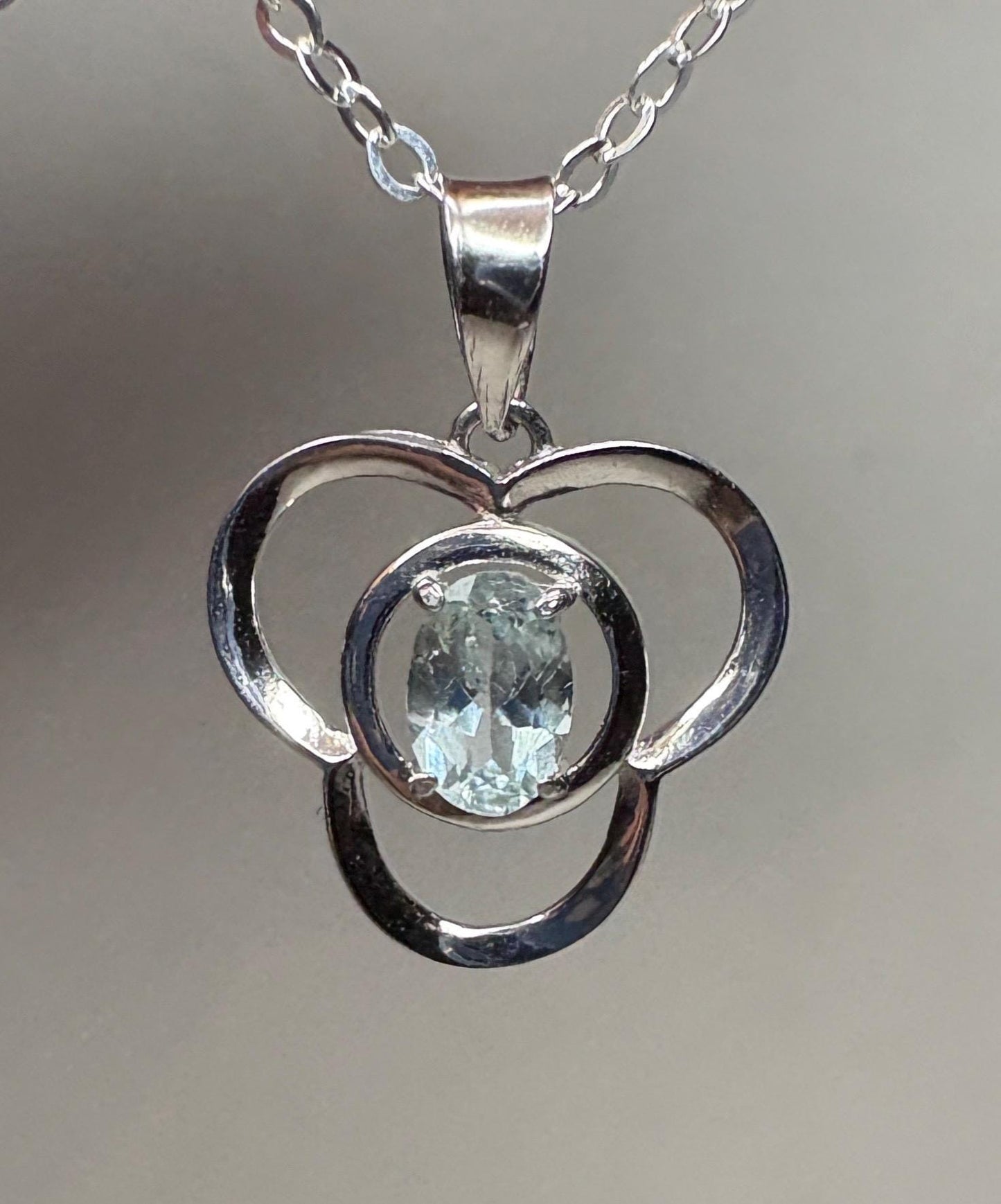 Sterling silver pendant necklace with a light blue oval tourmaline in a clover design.