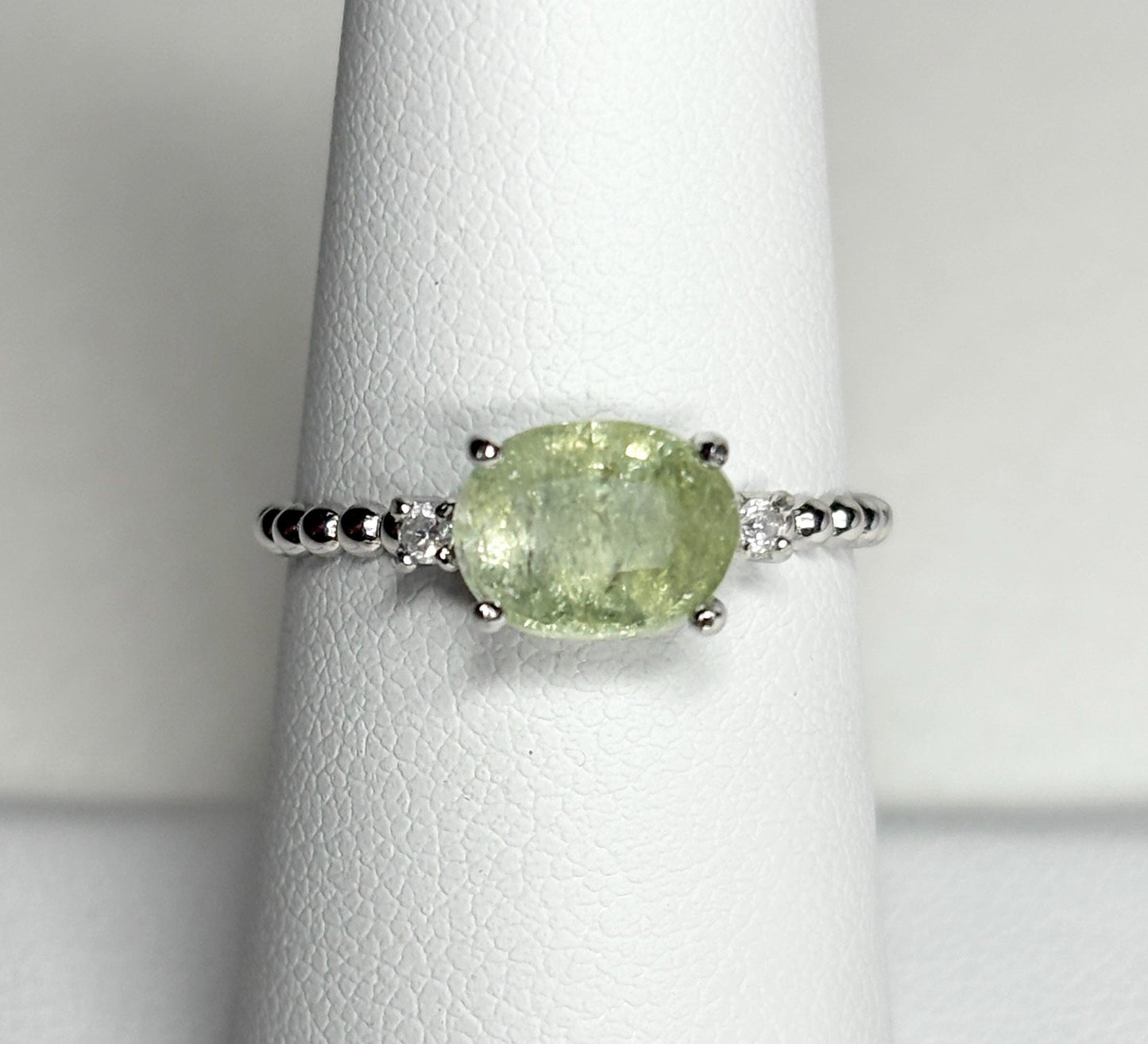 Sterling silver ring with a green oval tourmaline and two diamonds.