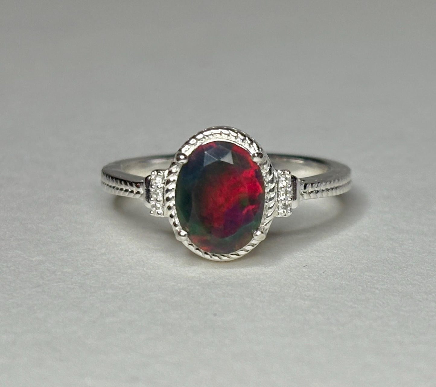 Oval Ethiopian black opal ring with zircons in sterling silver.