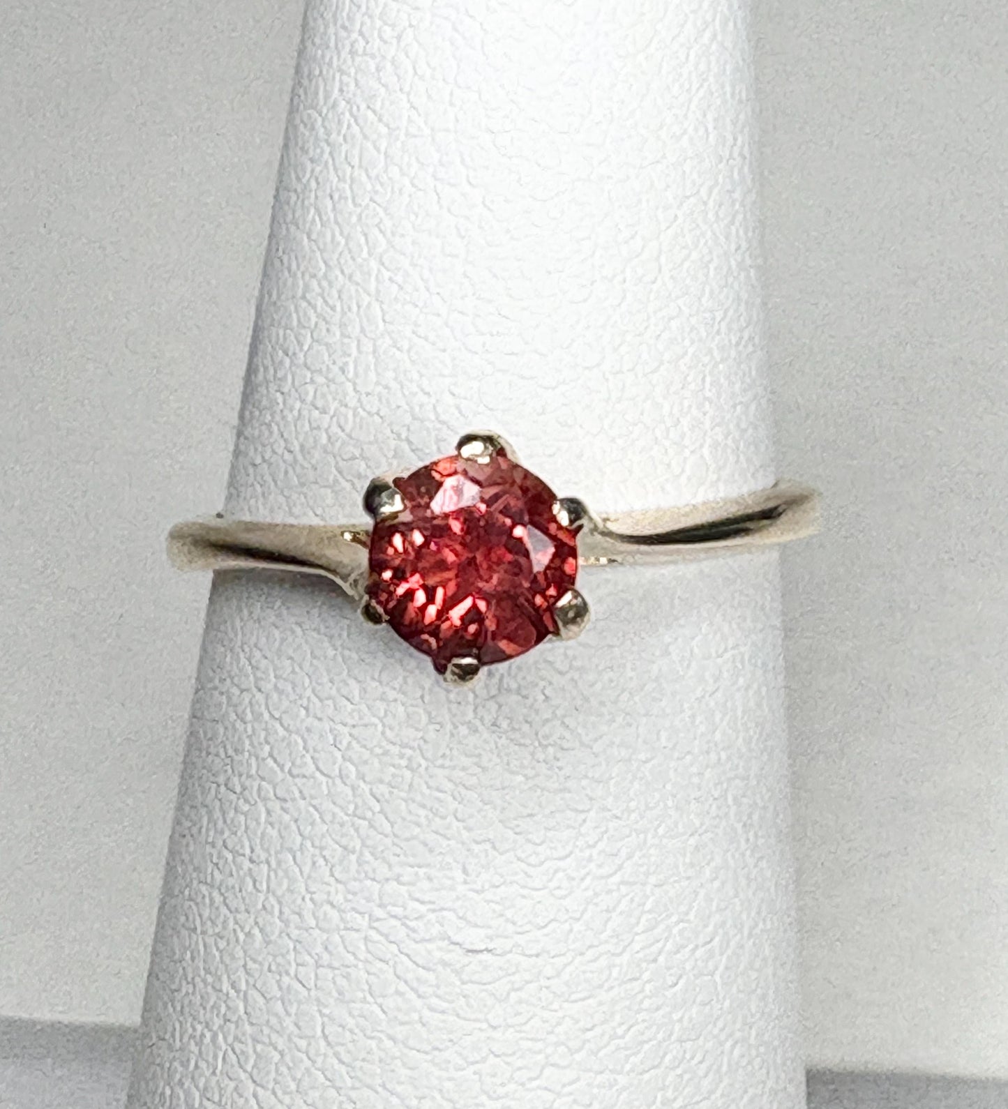 A red Oregon sunstone solitaire ring in 10k gold.