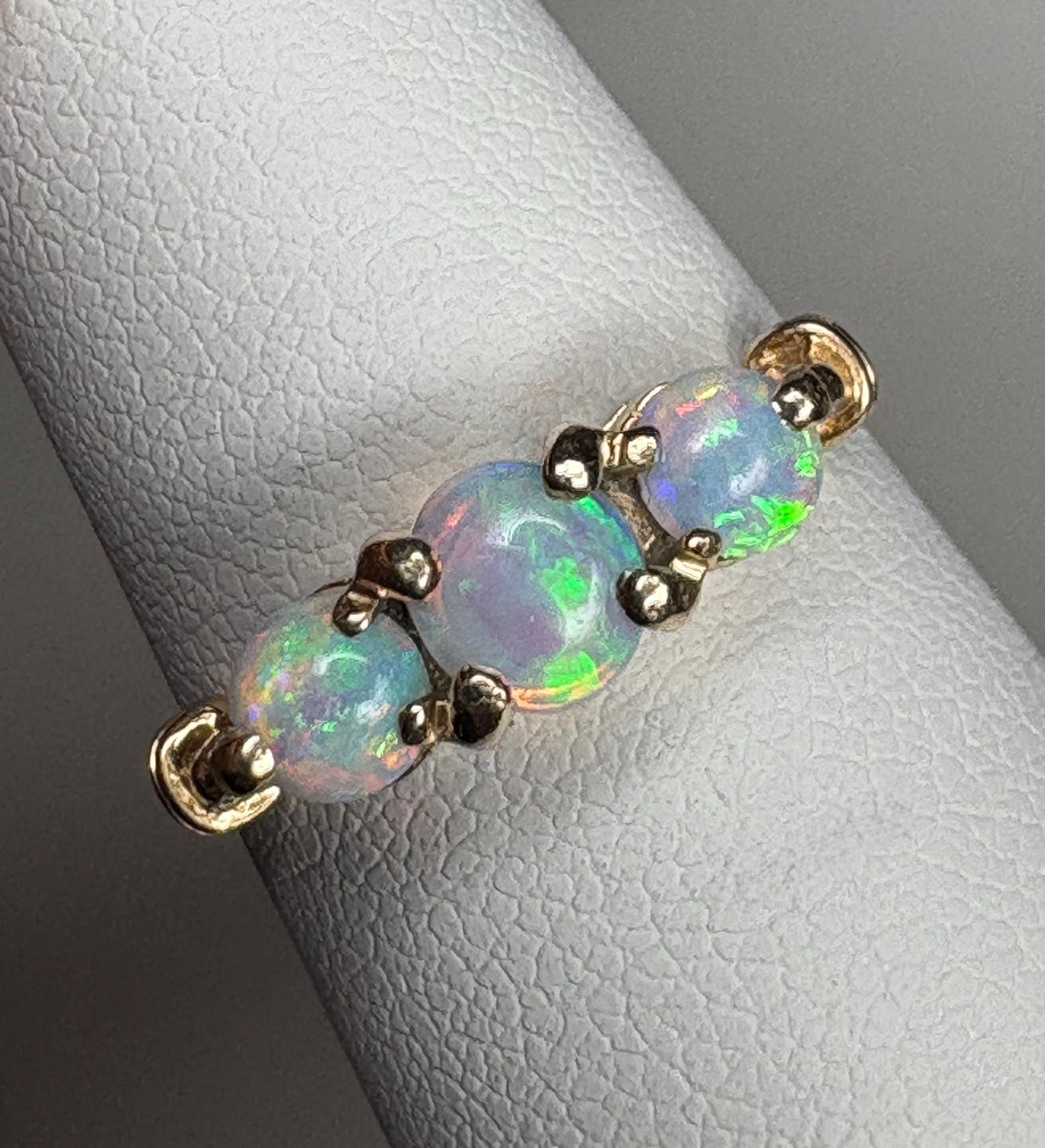 A 14k gold ring with three Australian opals.