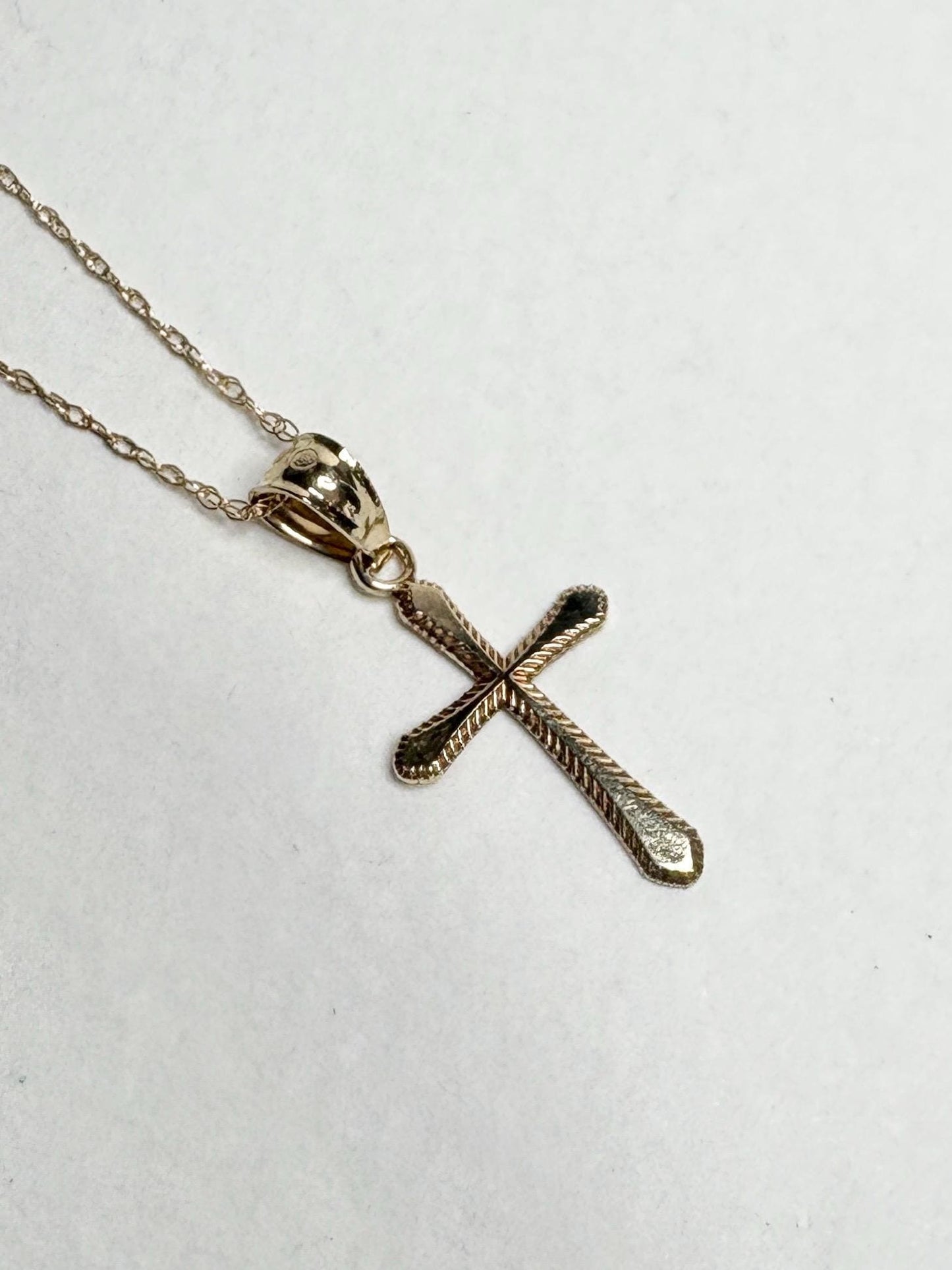 Solid 10k gold cross pendant necklace with a fine rope chain.