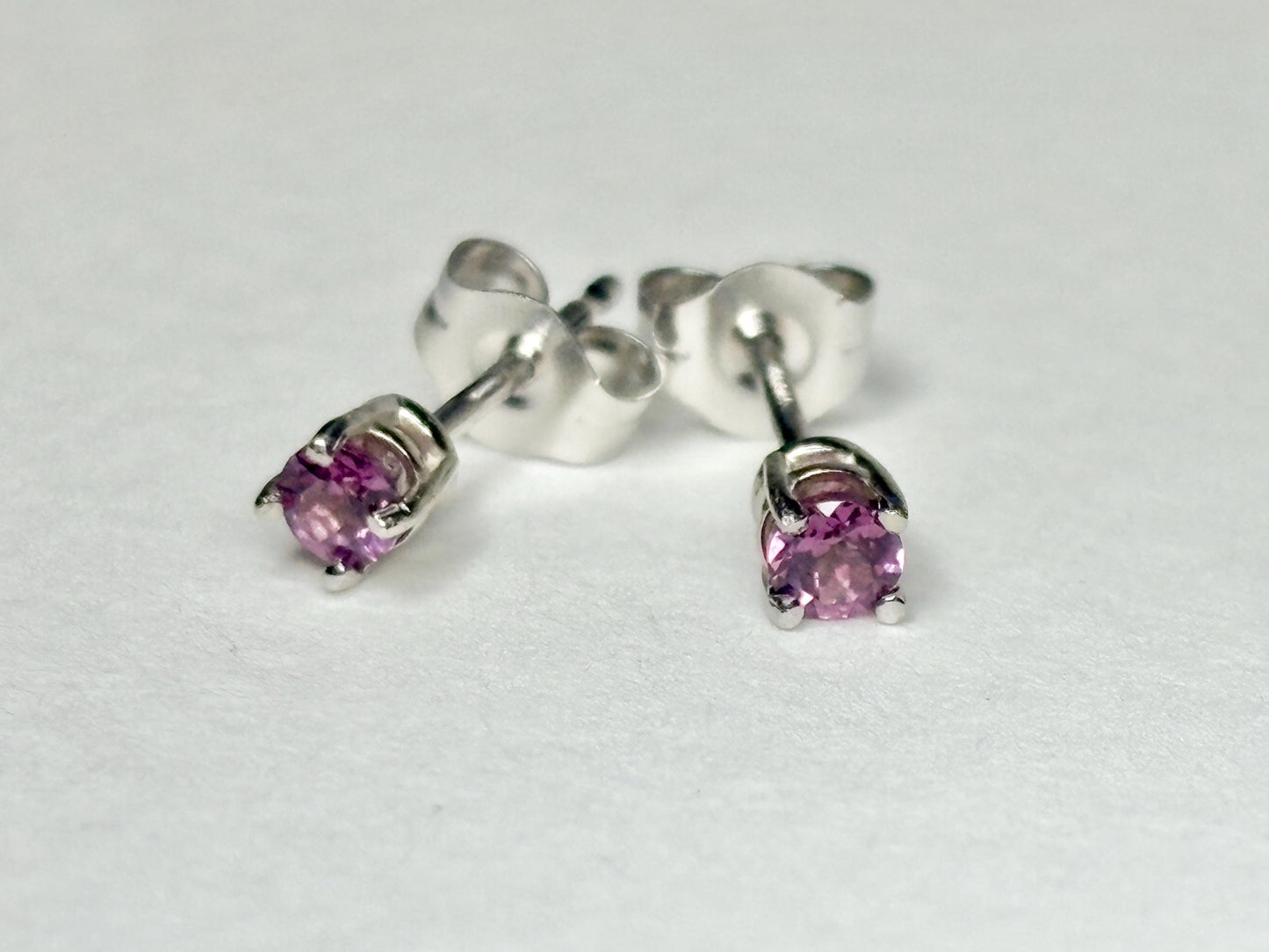 Pair of 2.75mm round rhodolite garnet stud earrings in 14k white gold.
