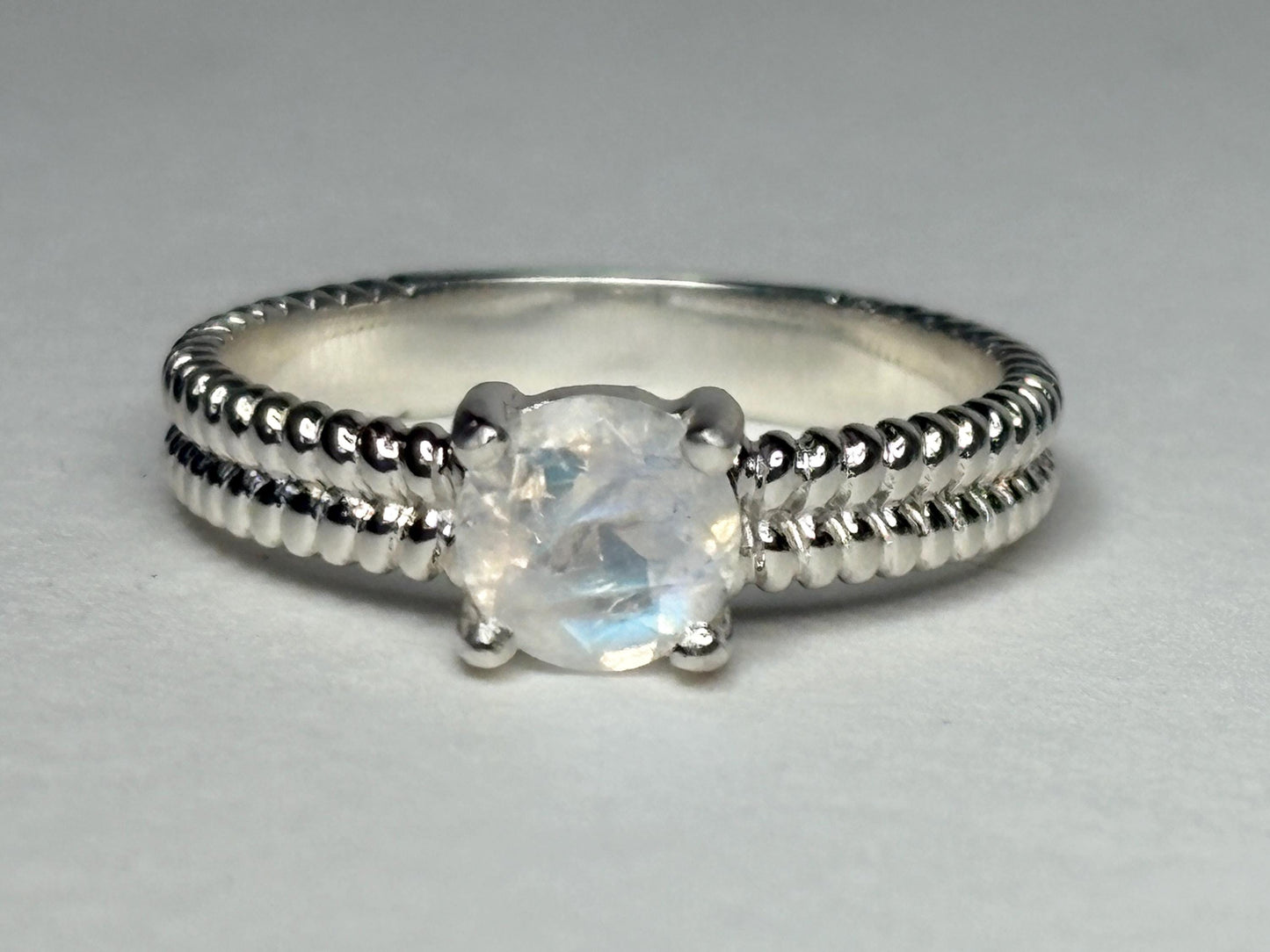 Sterling silver ring with a rainbow moonstone and double rope band.