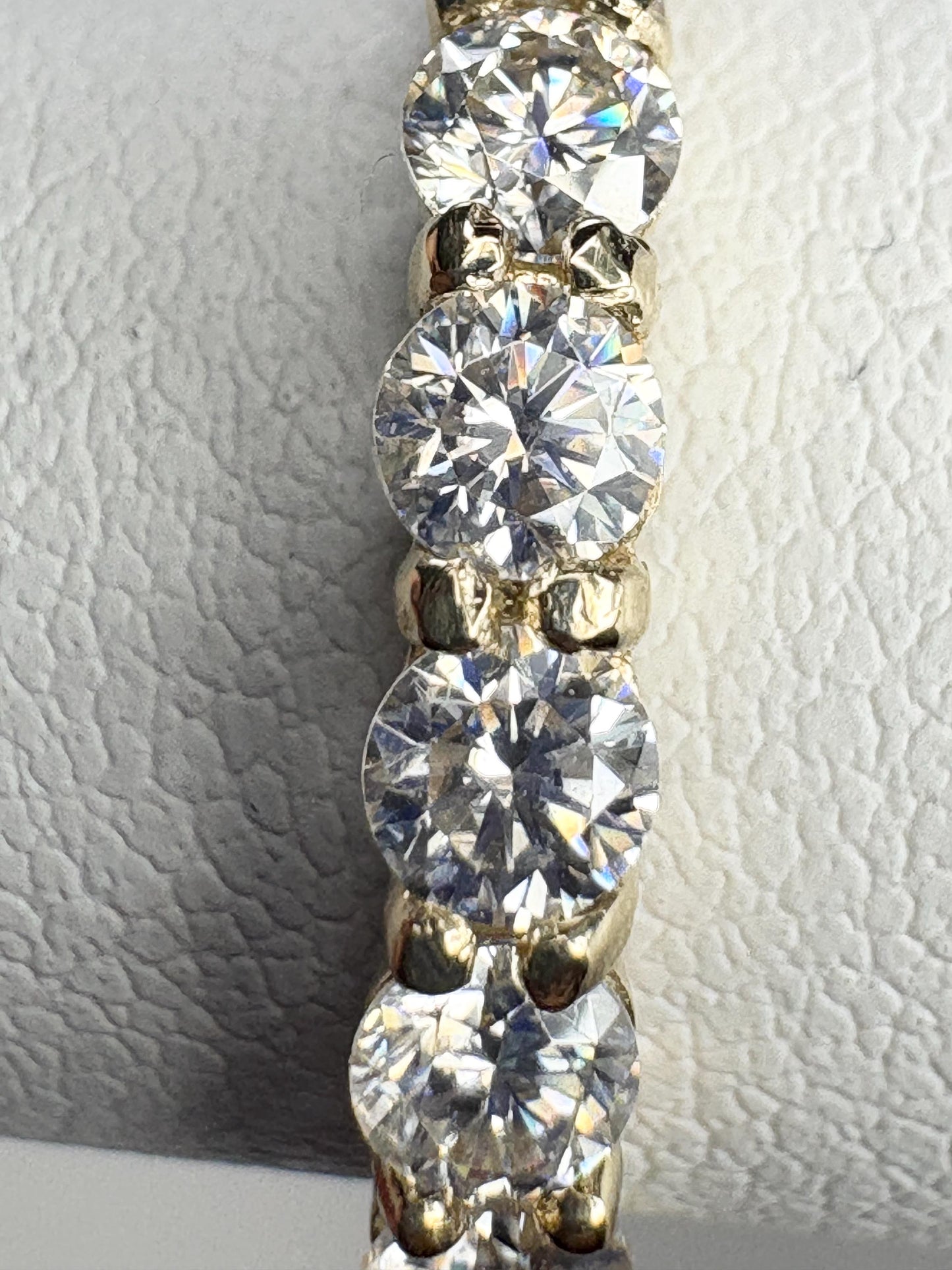 Solid 10k gold band ring with seven round moissanite stones.