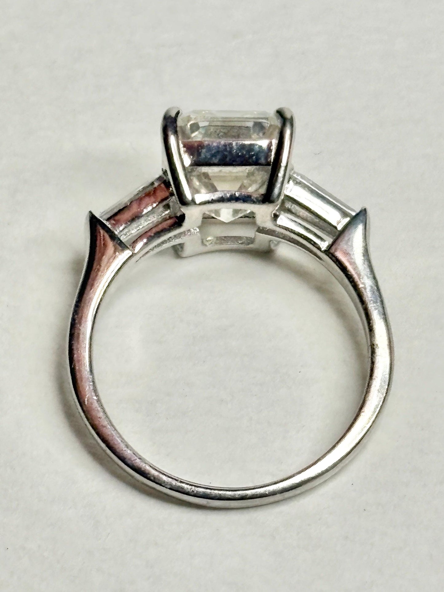 Sterling silver ring with an emerald-cut cubic zirconia and two baguette side stones.