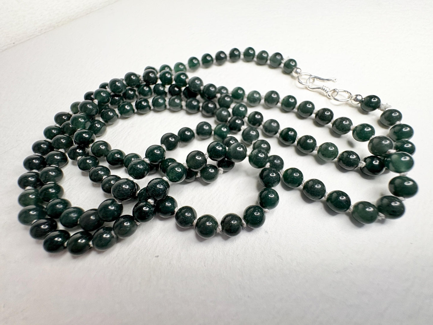 A long teal jadeite jade beaded necklace with a sterling silver clasp.