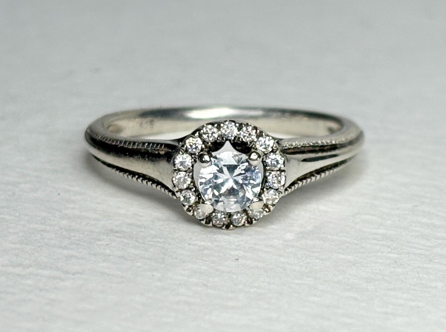 Sterling silver ring with a white sapphire surrounded by a diamond halo.