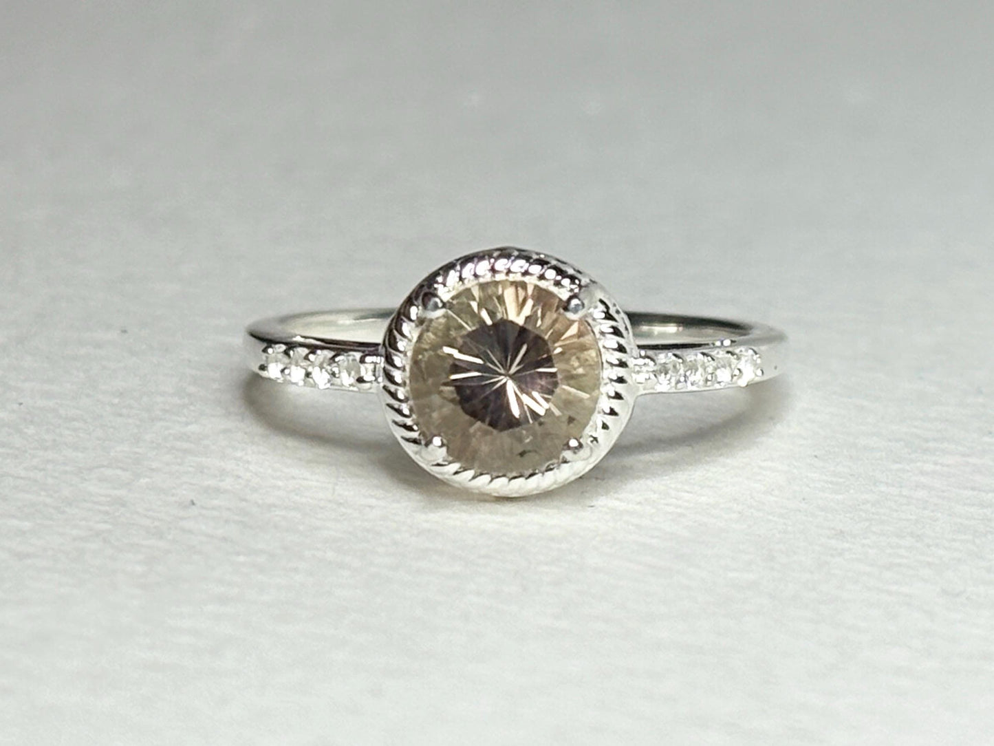 Sterling silver ring with a peach Oregon sunstone and white topaz accents.