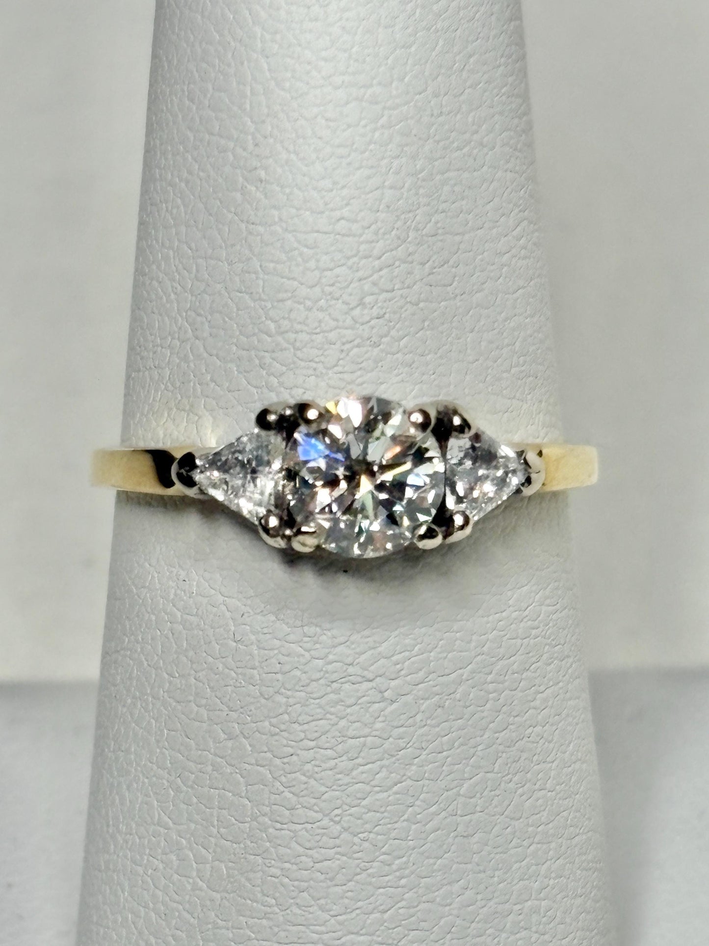 GIA certified diamond ring with round and trillion stones in 18k gold.