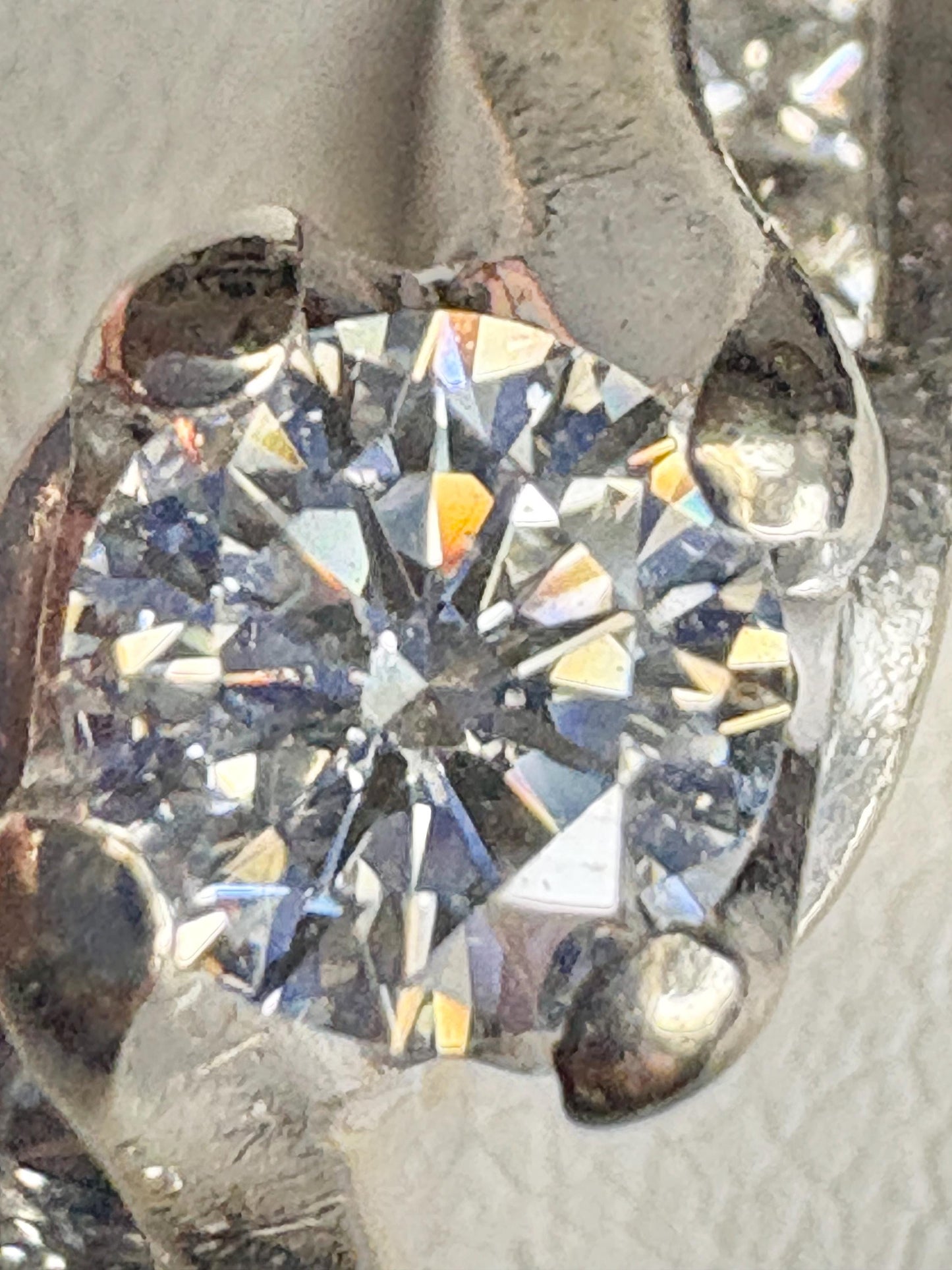 A vintage 14k white gold ring with a central diamond and channel-set princess cut diamonds.