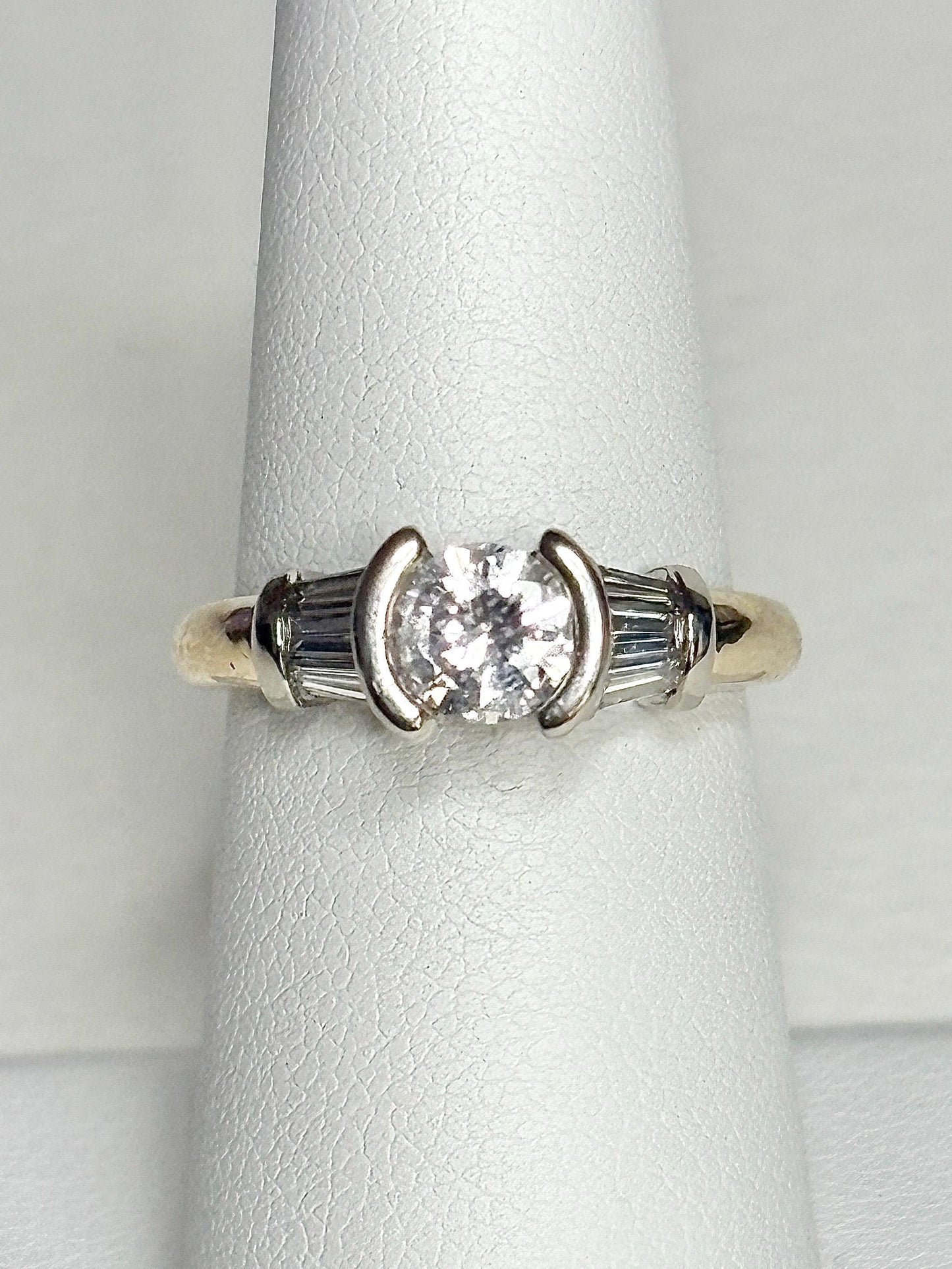 14k gold ring with a round diamond and baguette diamonds.