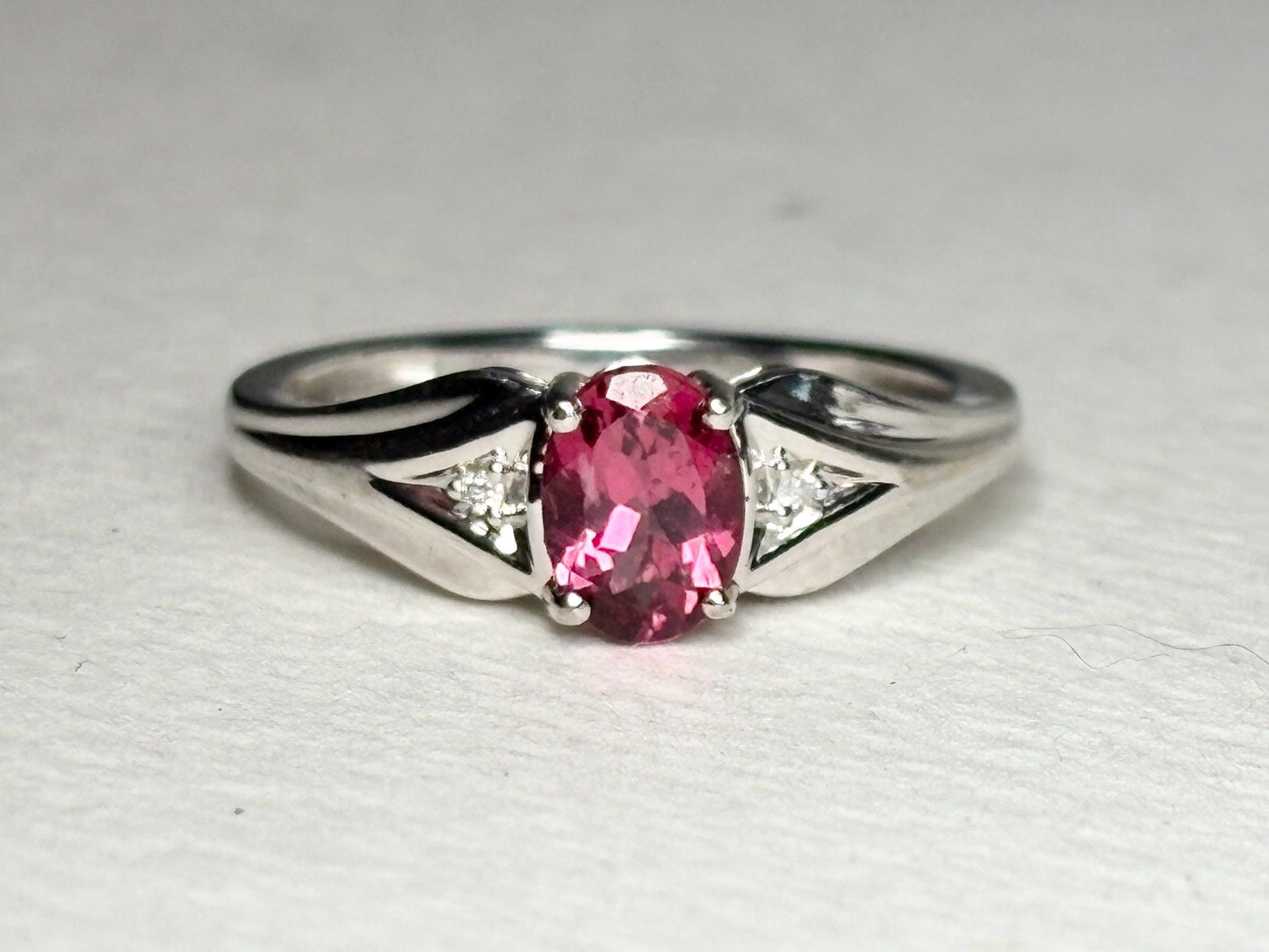Oval pinkish red rubellite tourmaline and diamond ring in white gold.