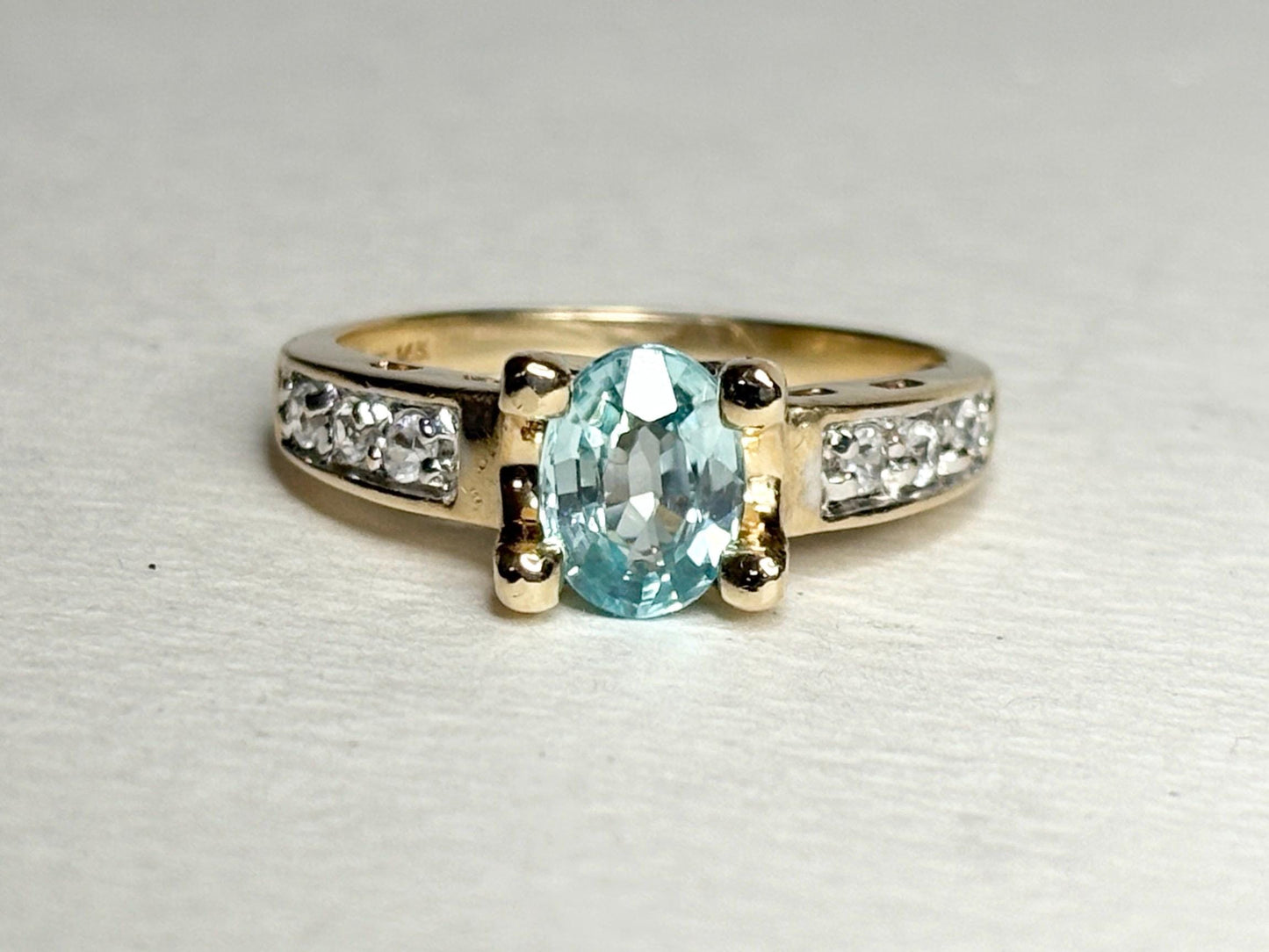 Oval blue zircon and clear side stone two-tone 14k gold ring.