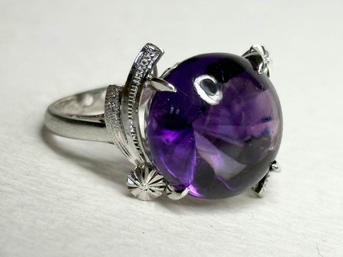 Art Deco amethyst ring in rhodium over sterling silver with a faceted bottom and buff top.