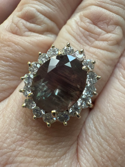 A large oval dichroic Oregon sunstone ring with a diamond halo in 14k gold.