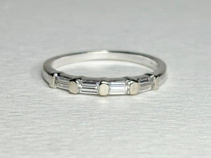 A 14k white gold band ring with five baguette-cut moissanite stones.
