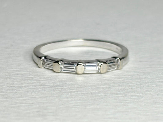 A 14k white gold band ring with five baguette-cut moissanite stones.