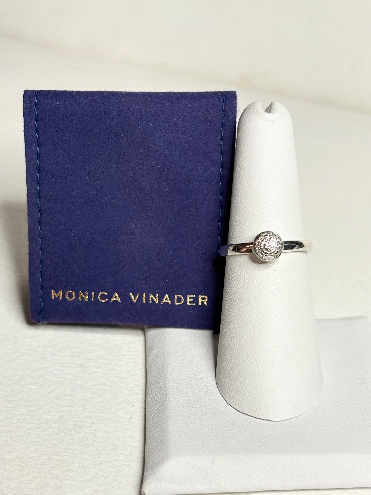 Monica Vinader sterling silver ring with pave diamonds on a white display stand.