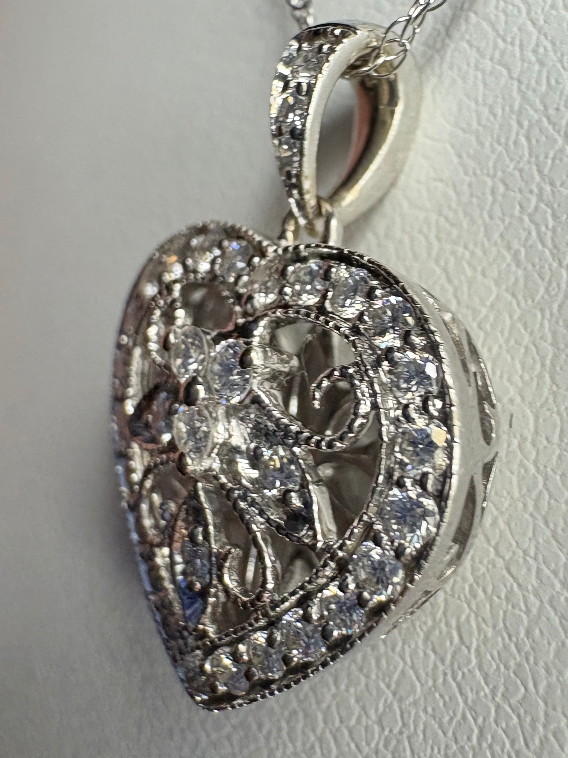 A heart-shaped pendant necklace with diamonds in 14k white gold.