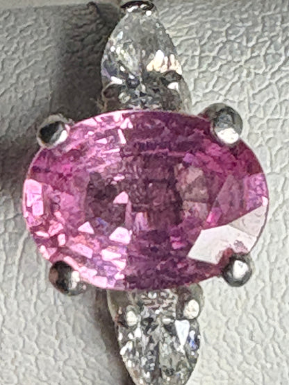 Platinum ring with an oval pink sapphire and pear-shaped diamonds.