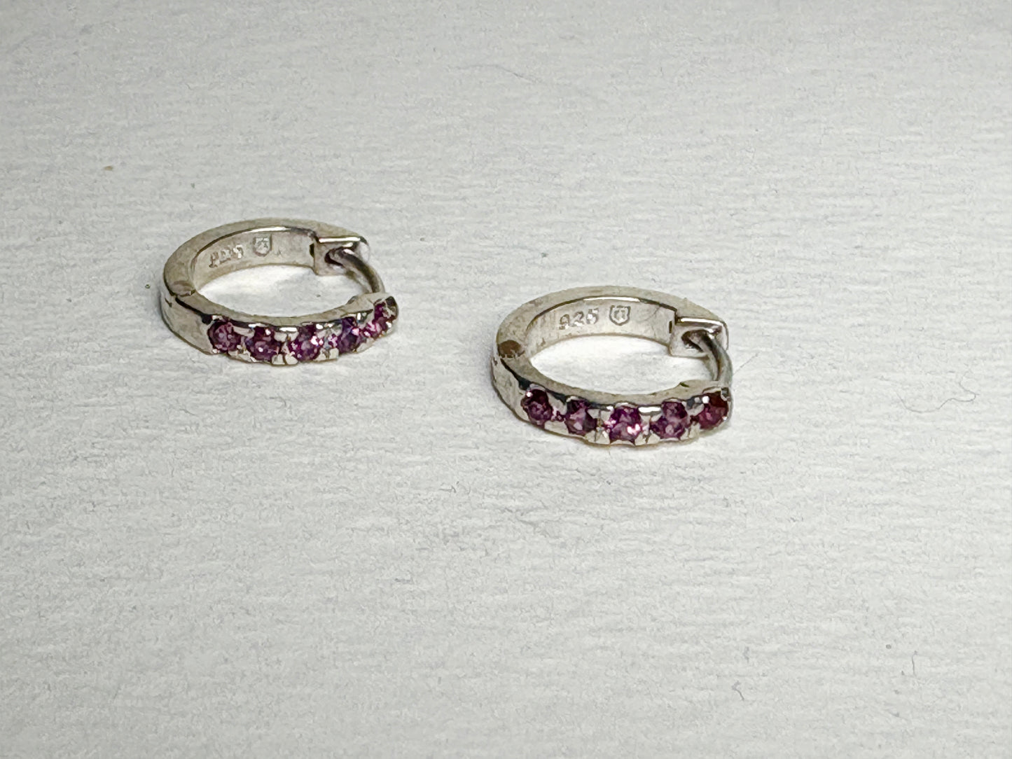 Sterling silver small huggie hoop earrings with rhodolite garnets.