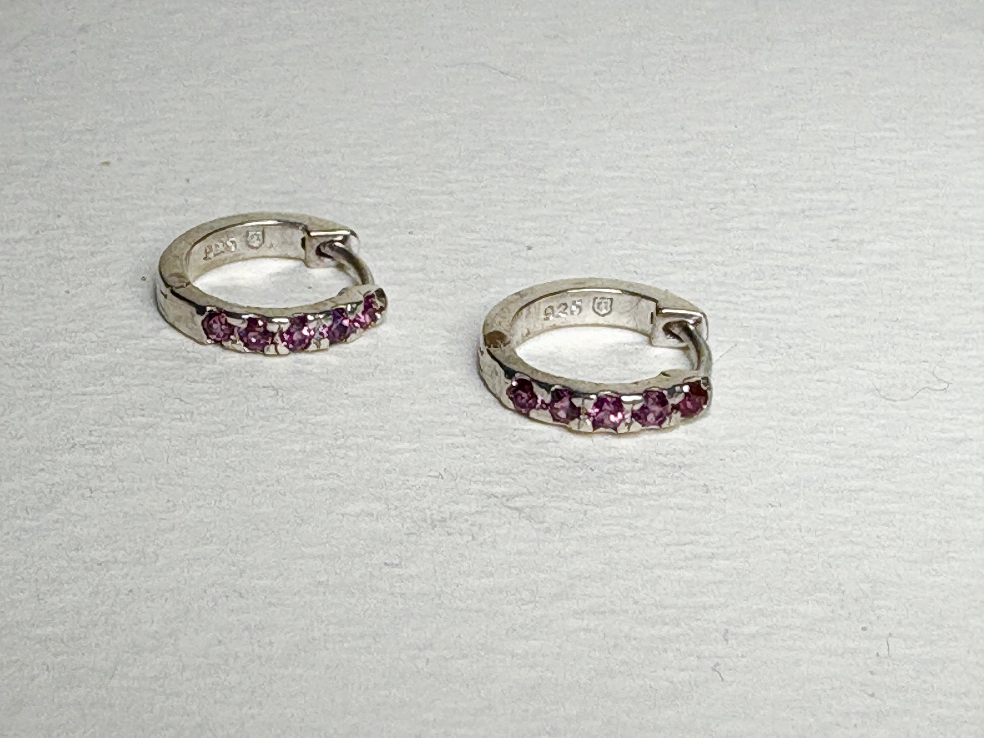 Sterling silver small huggie hoop earrings with rhodolite garnets.